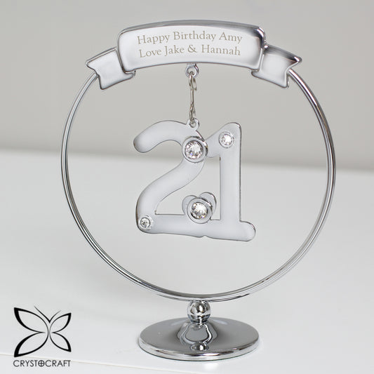 Silver '21' ornament with engraved text on a clear stand, featuring Crystocraft logo.
