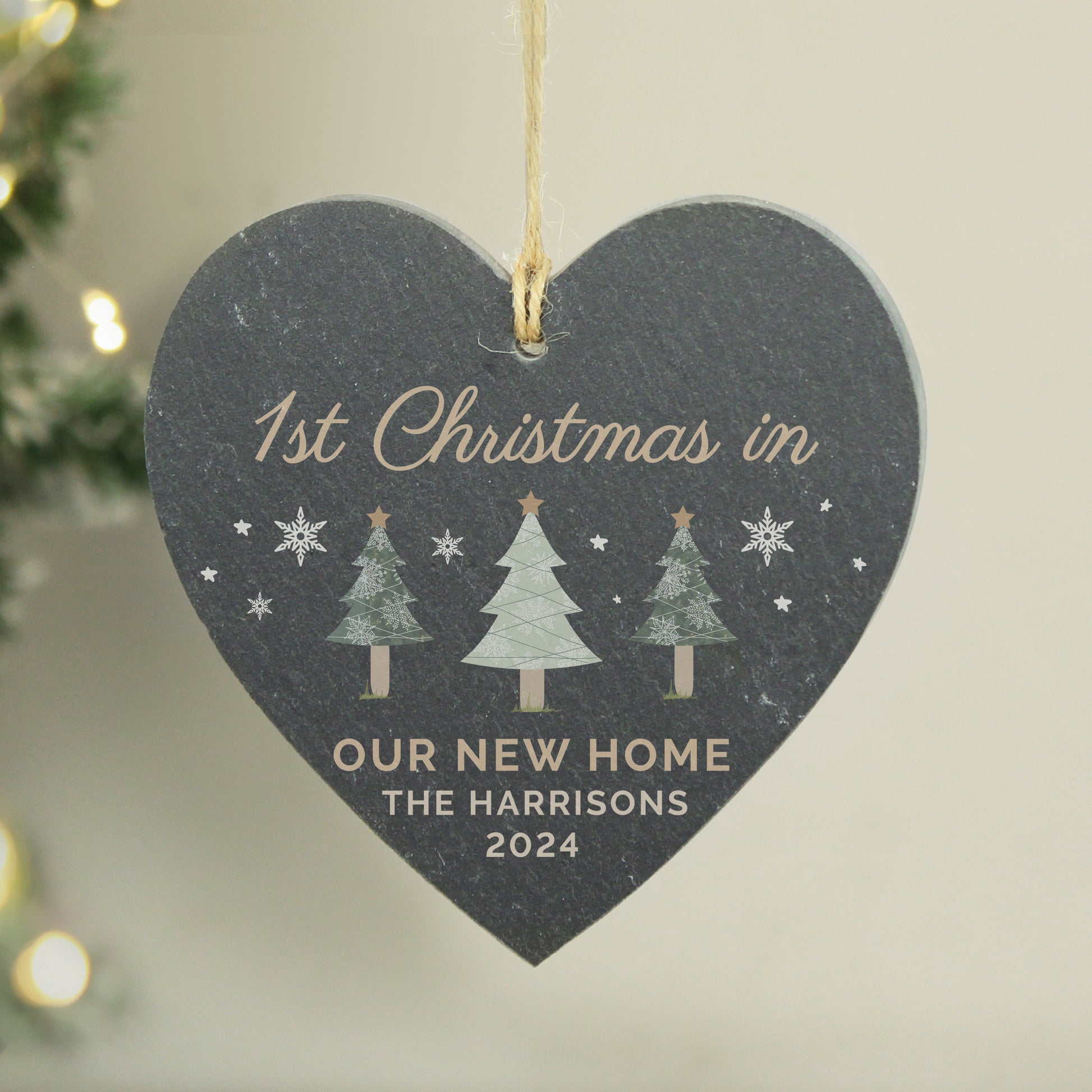 Heart-shaped decorative plaque for '1st Christmas in Our New Home' with personalized text, hanging against a neutral background.