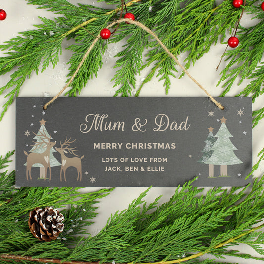 Personalised Christmas-themed decorative sign with reindeer and trees, surrounded by greenery and berries.