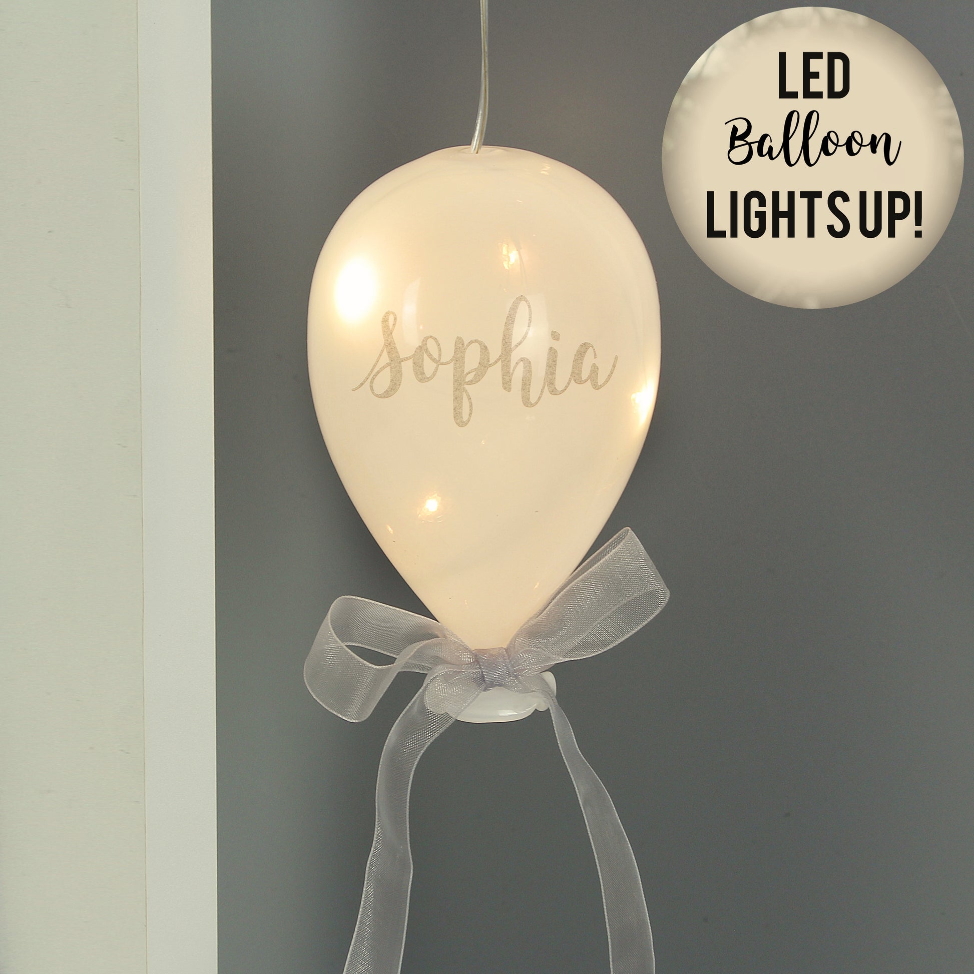 LED balloon with 'Sophia' written on it, featuring a bow and text 'LED Balloon LIGHTS UP!' on a grey background.