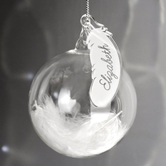 Decorative ornament with feather and engraved name tag on a blurred background