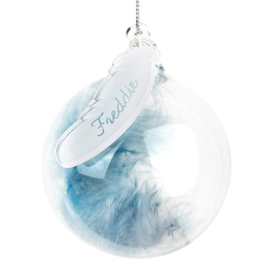 Decorative feather ornament with 'Freddie' tag on a white background