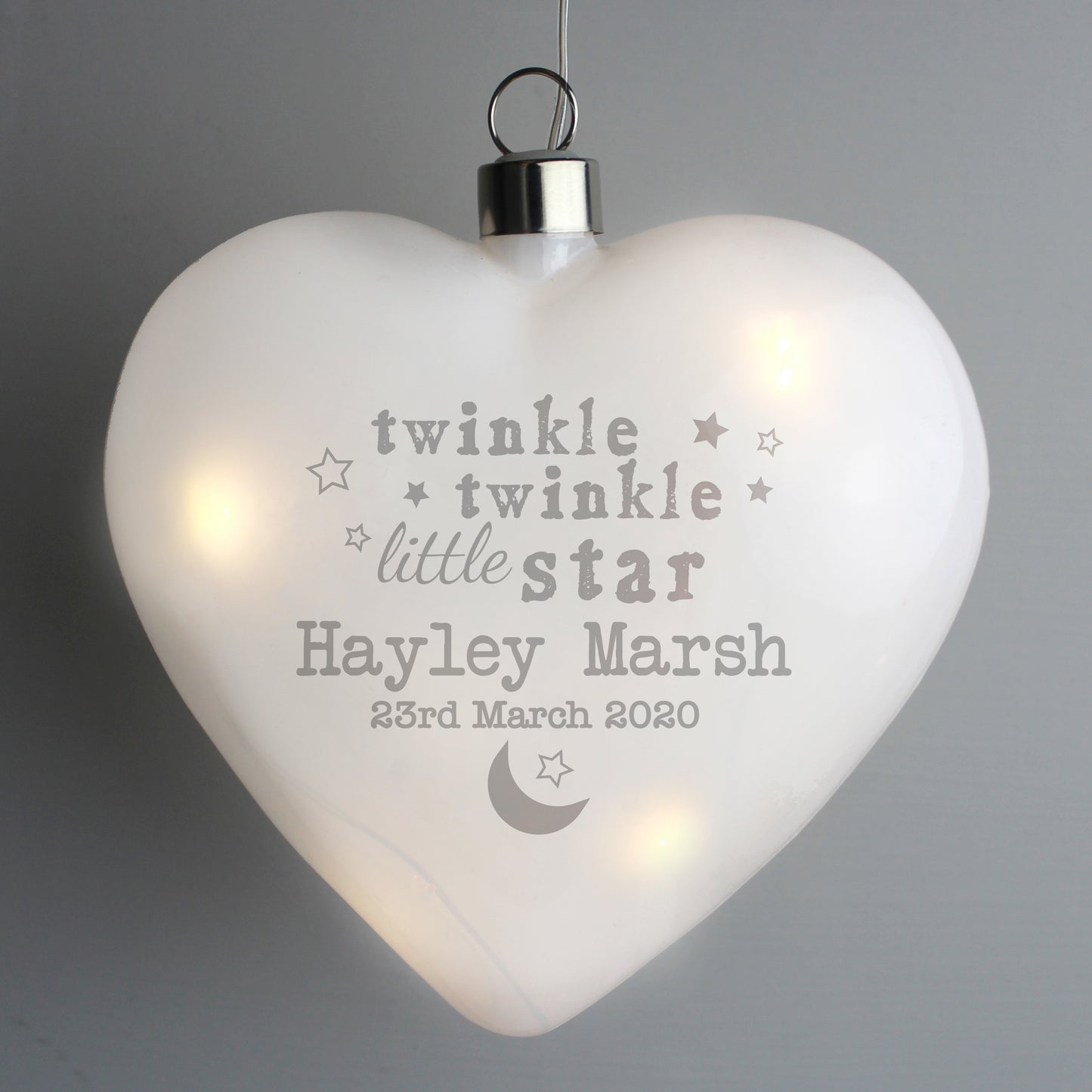 Heart-shaped light with engraved text on a gray background