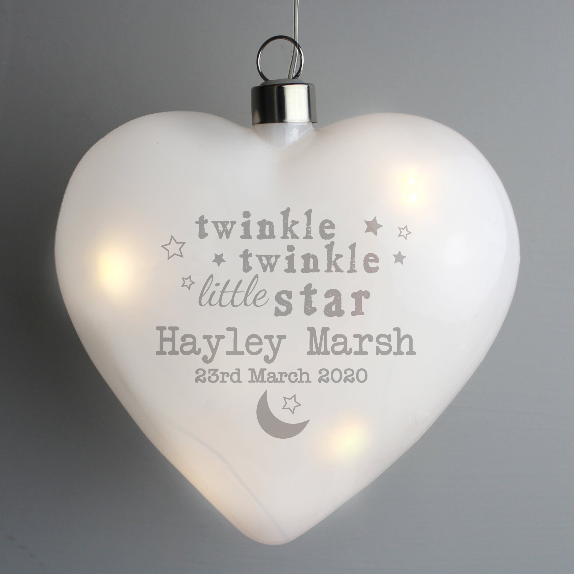 Heart-shaped light with engraved text on a gray background