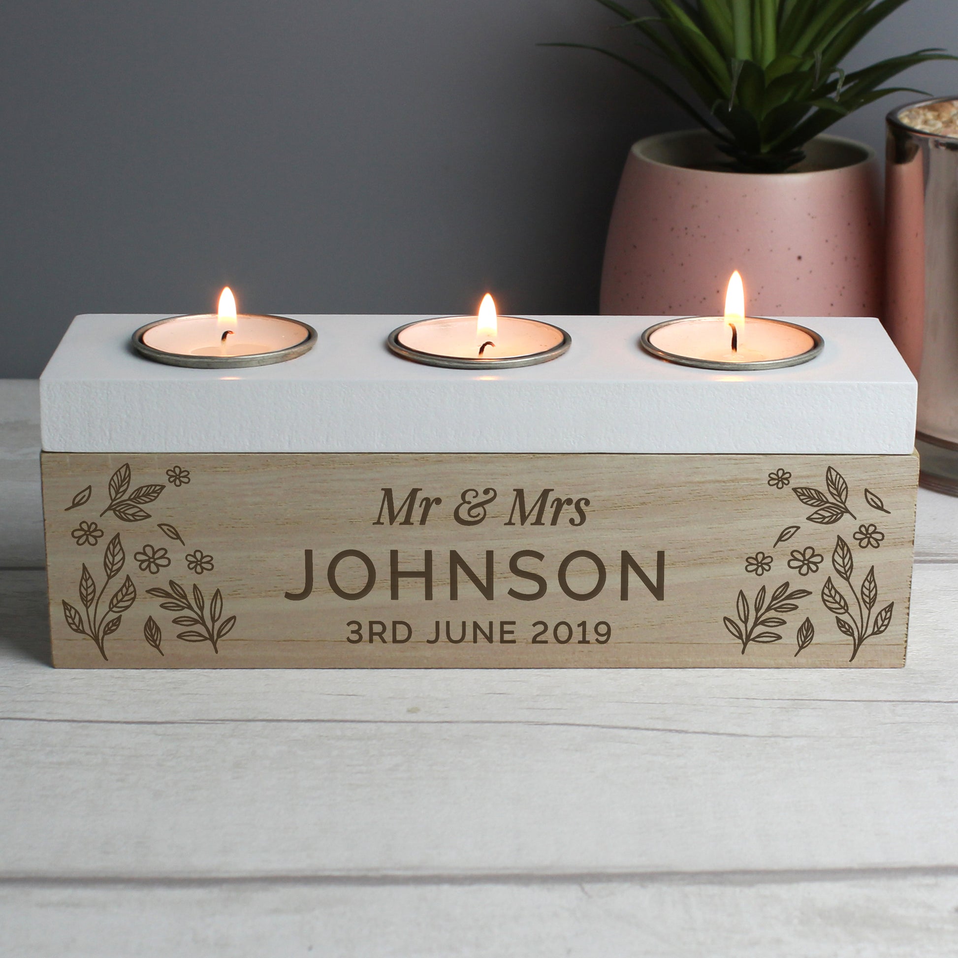 Three-wick candle holder with 'Mr & Mrs Johnson 3rd June 2019' engraving on a wooden base.