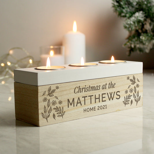 Wooden candle holder with engraved text 'Christmas at the MATTHEWS HOME 2021' on a reflective surface.