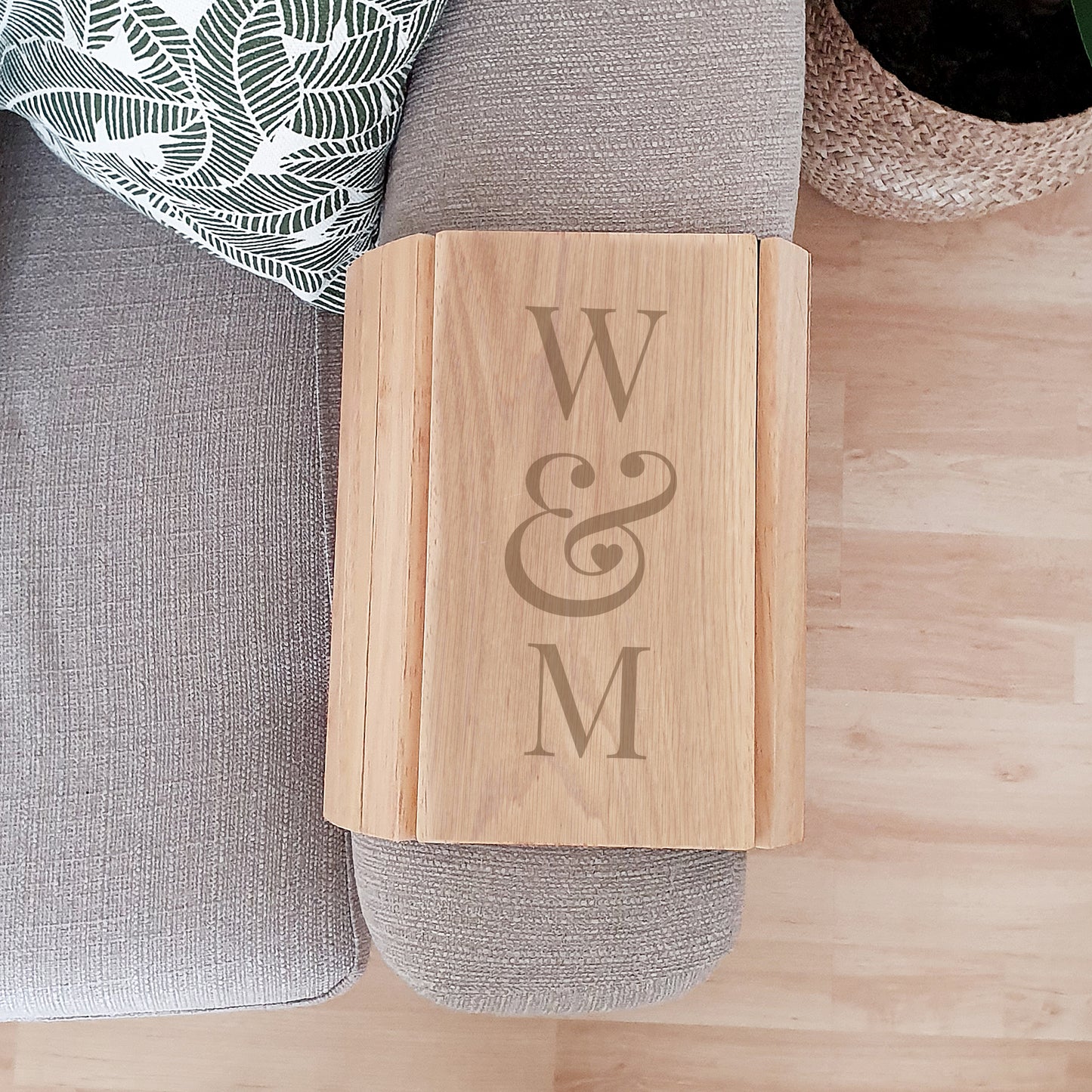 Personalised Wooden tray with 'W & M' engraving on a grey cushion.