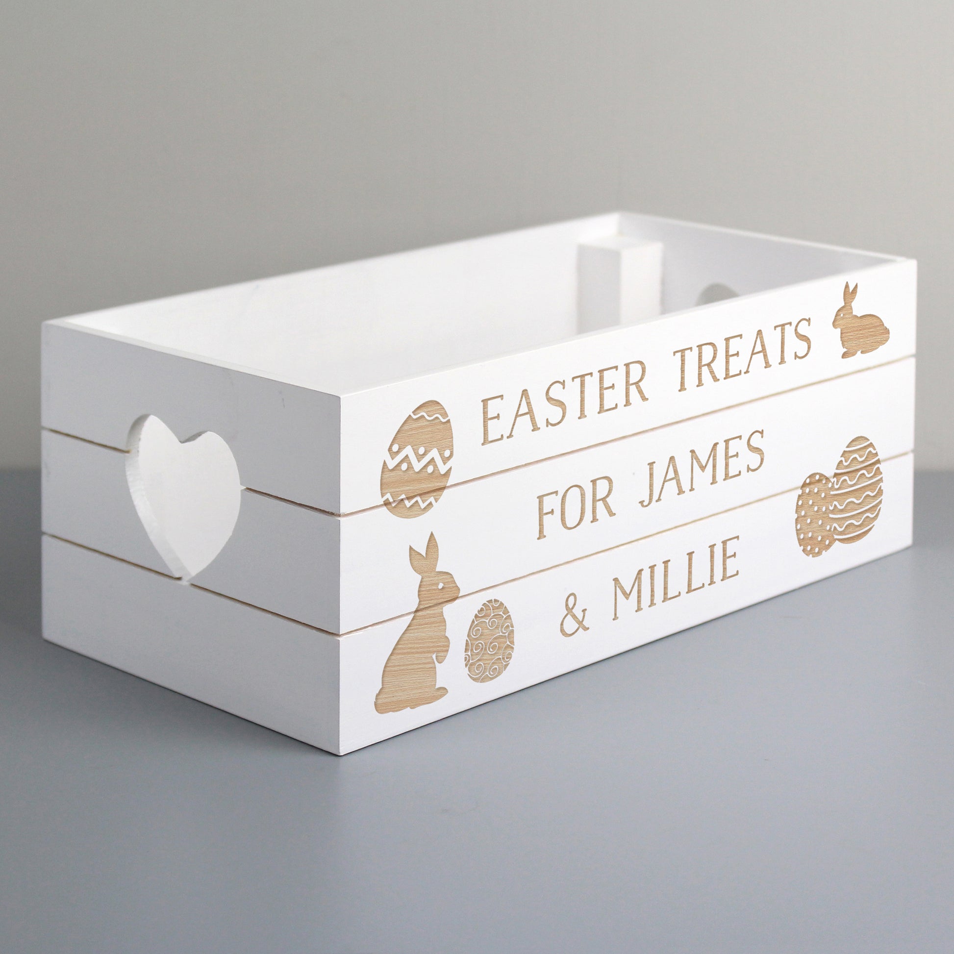 White wooden crate with text and Easter illustrations on a grey background