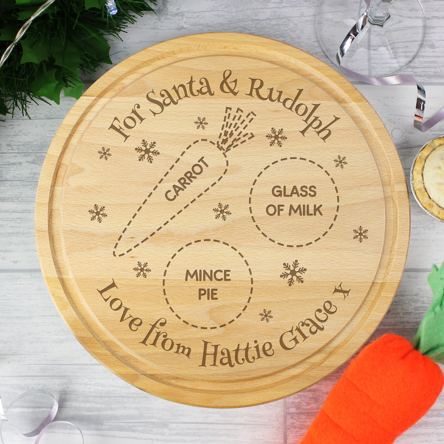 Wooden cutting board with engraved text for Santa and Rudolph, featuring a carrot, glass of milk, and mince pie.
