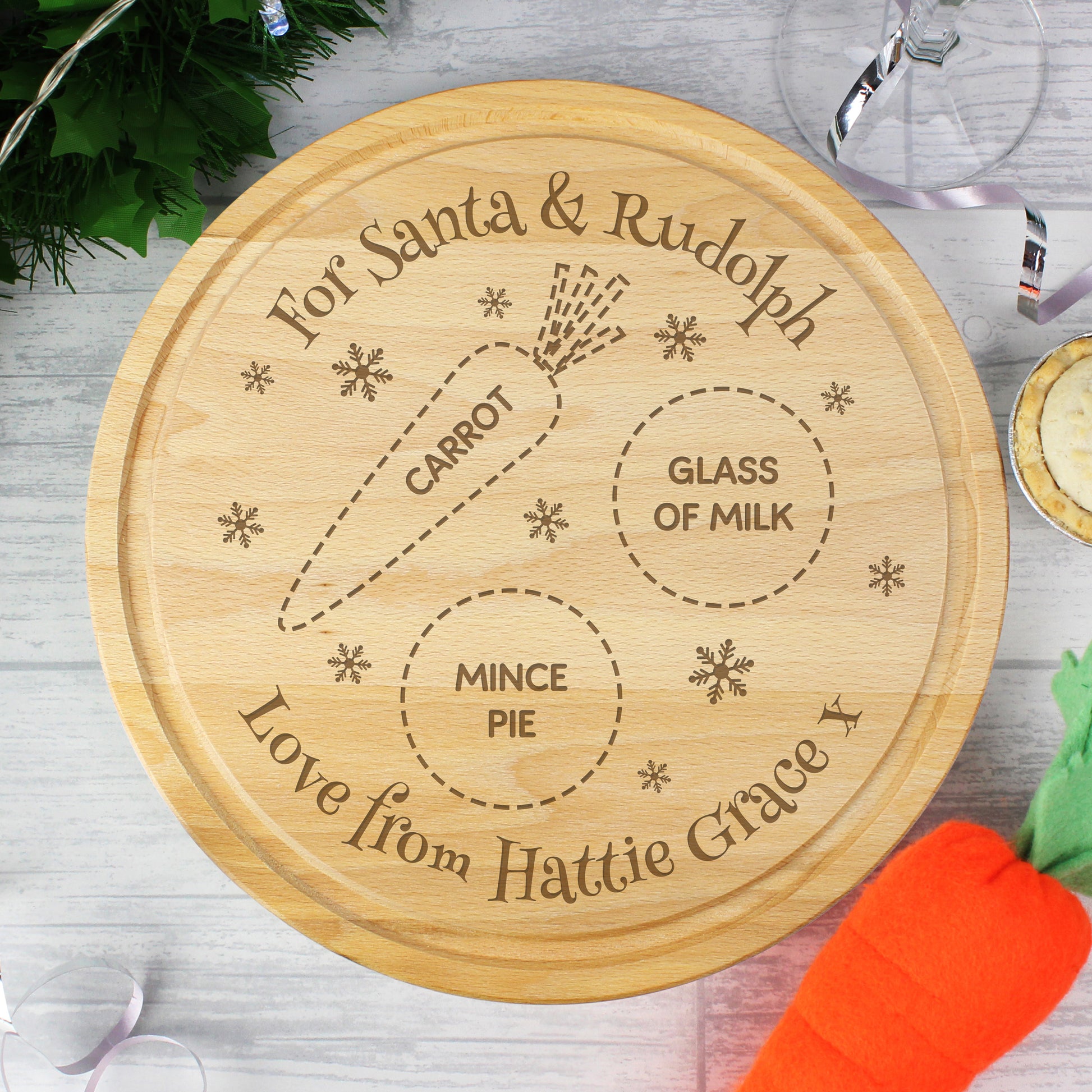 Wooden cutting board with engraved text for Santa and Rudolph, featuring a carrot, glass of milk, and mince pie.