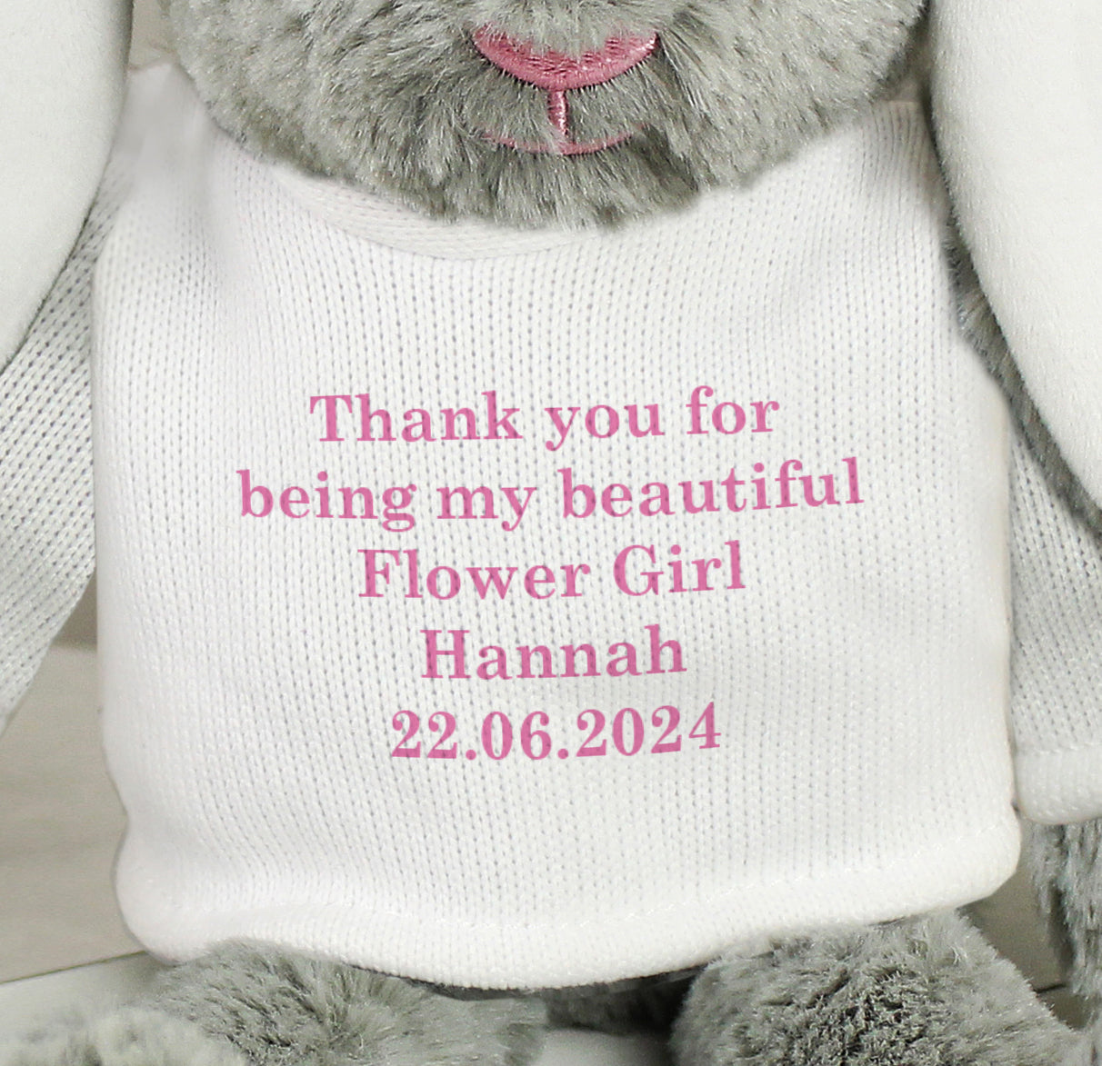 Grey bunny wearing a white sweater with pink text and date