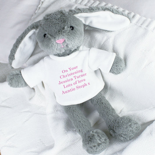 Grey plush bunny with a white shirt on a white blanket