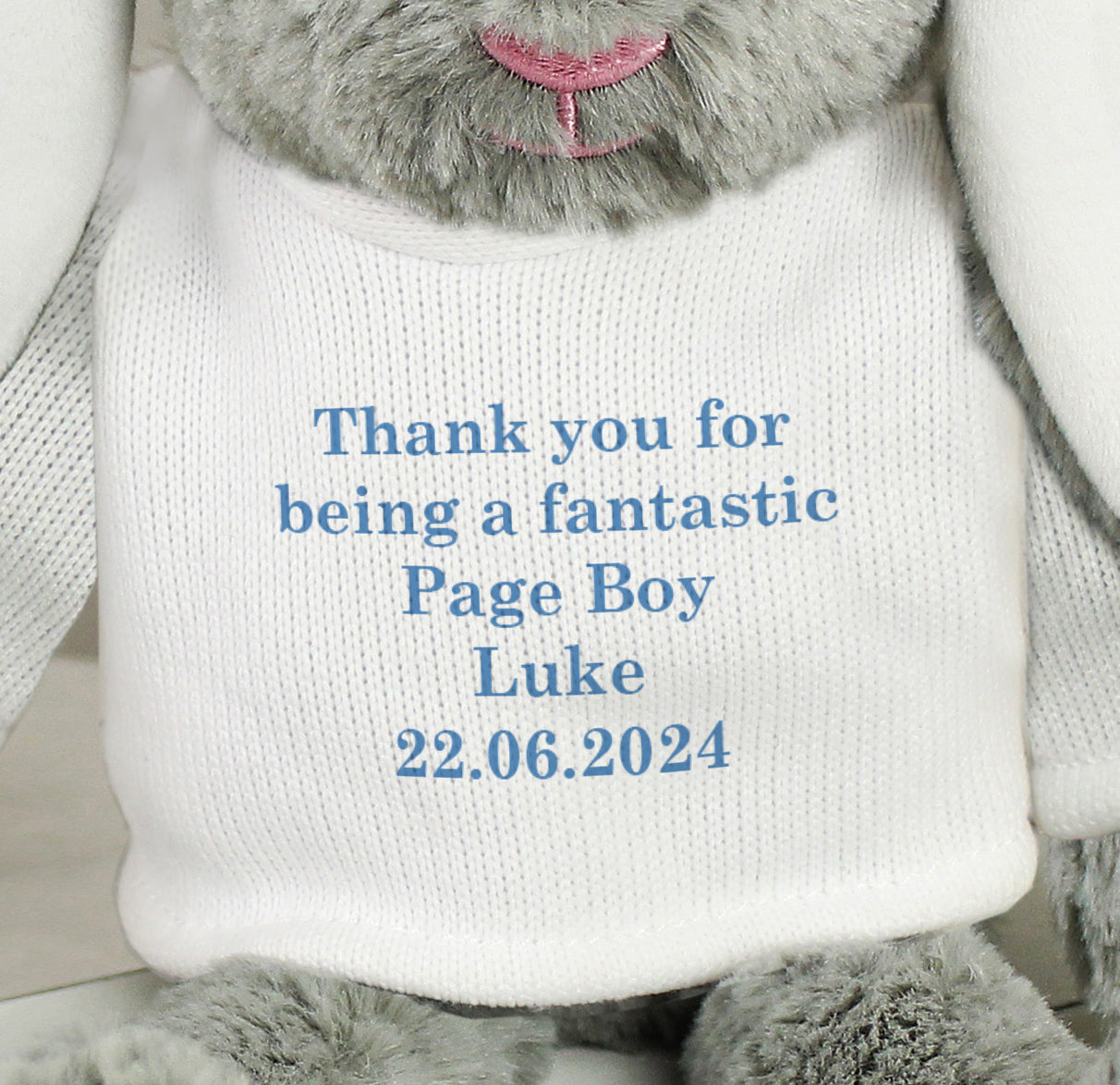 Grey plush toy with a white shirt displaying personalised text