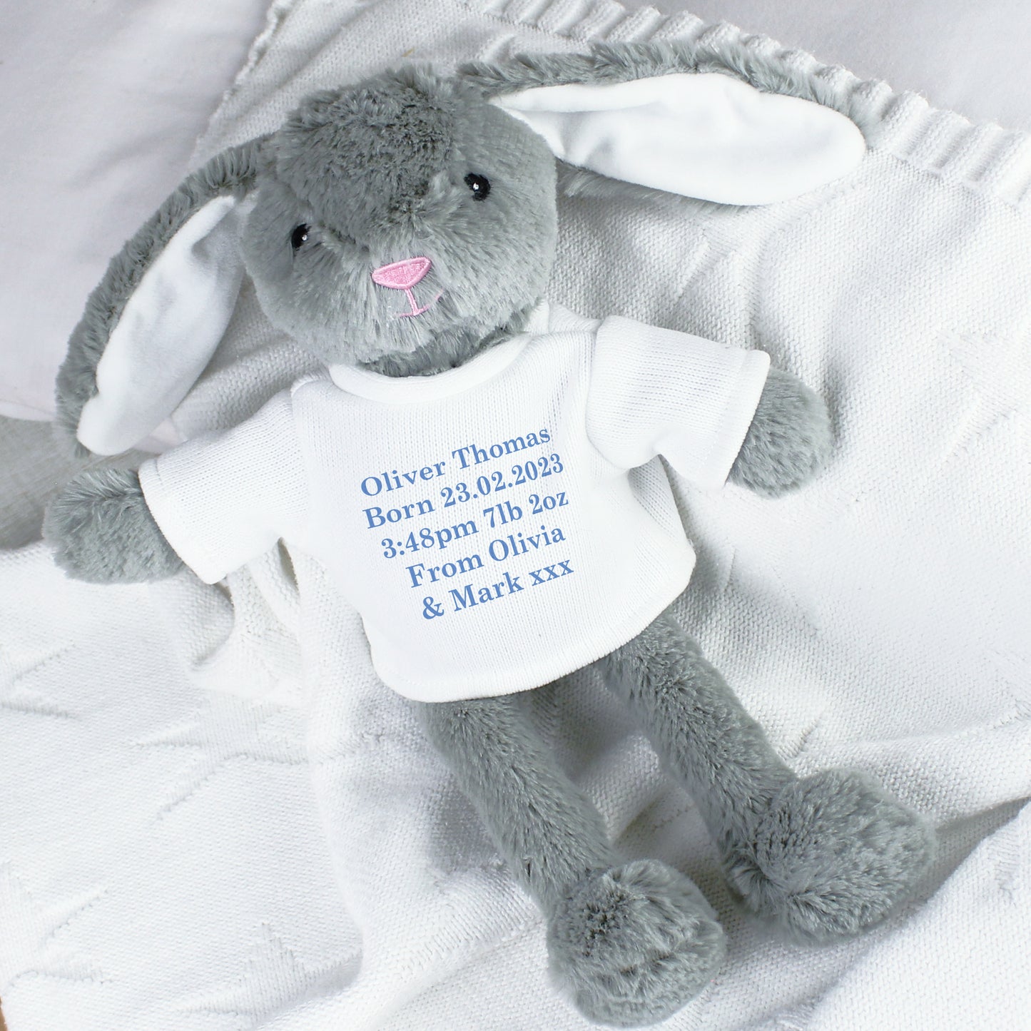 Personalised Grey plush bunny with a white shirt displaying baby birth details on a white blanket