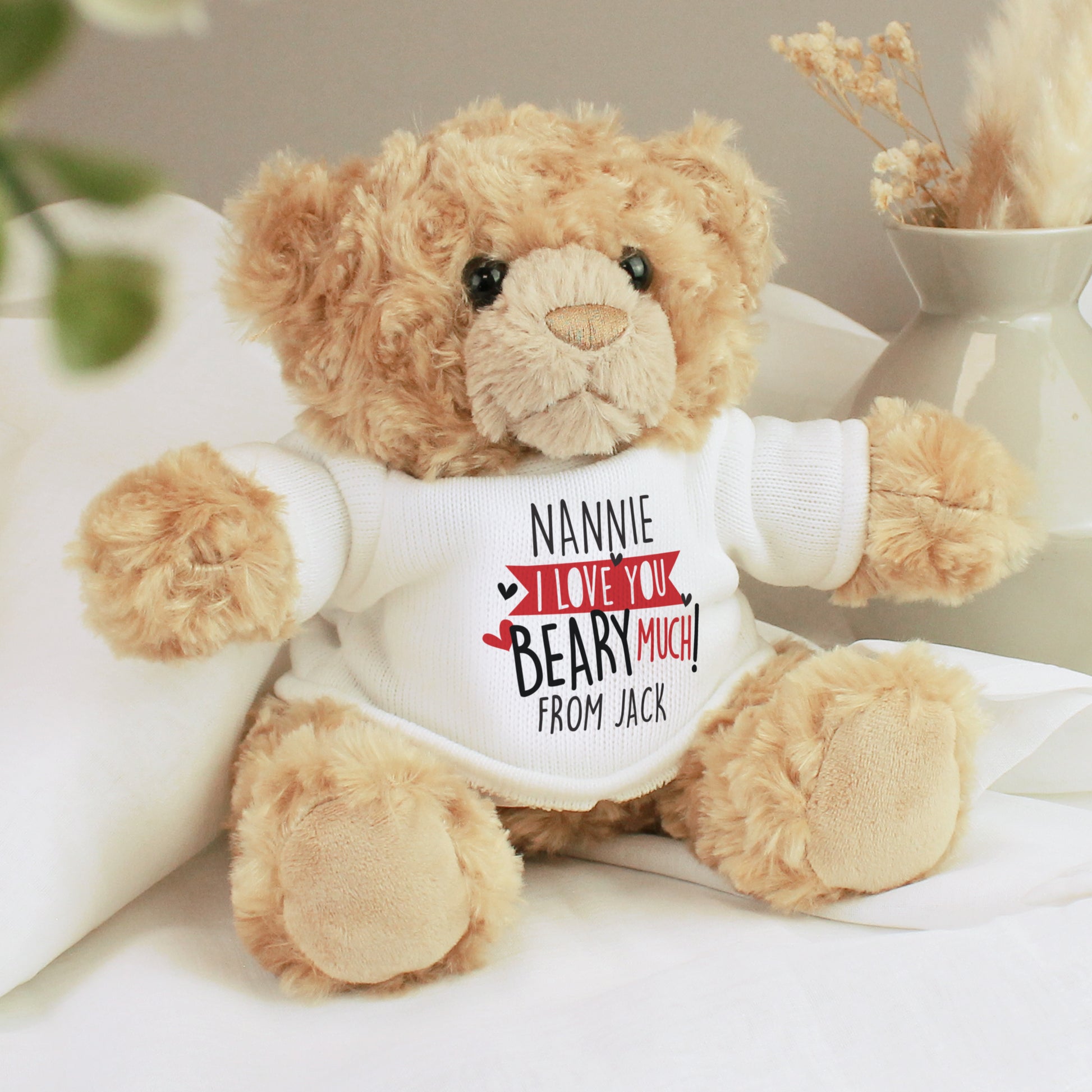 Teddy bear wearing a shirt with a personalised message on a light background