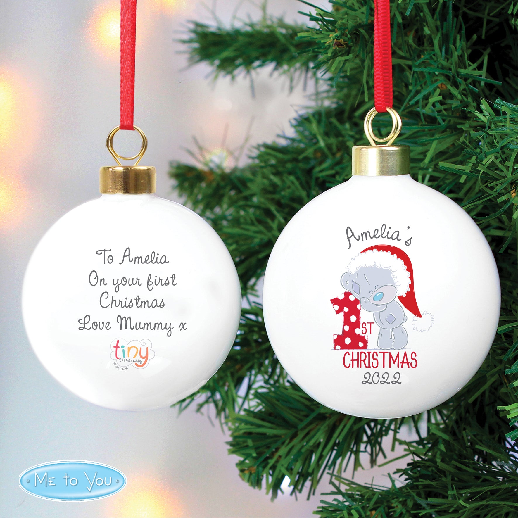 Christmas ornament with text and a teddy bear design on a tree.