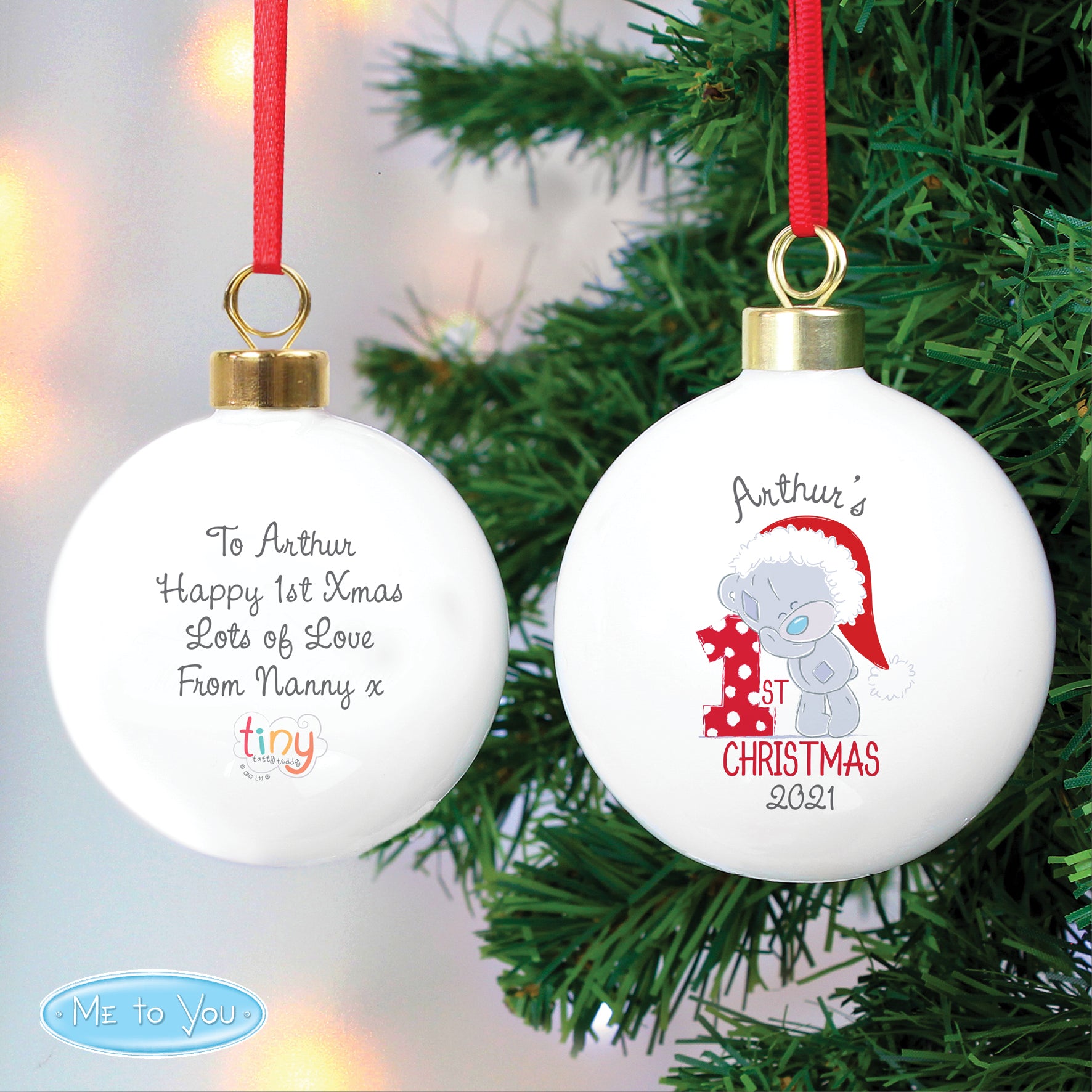 Christmas ornament with text and a teddy bear design on a tree.