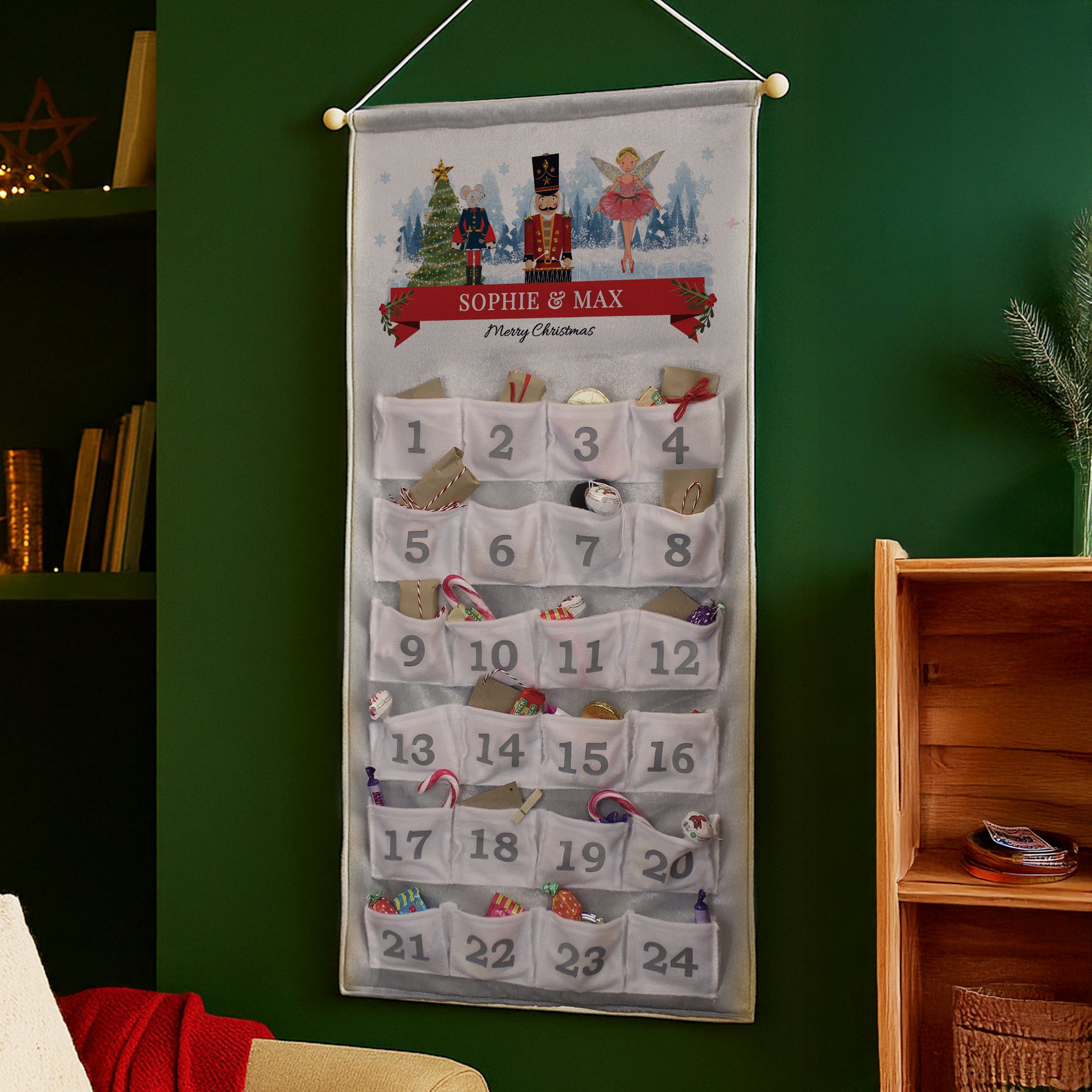 Christmas advent calendar with decorative elements on a green wall.