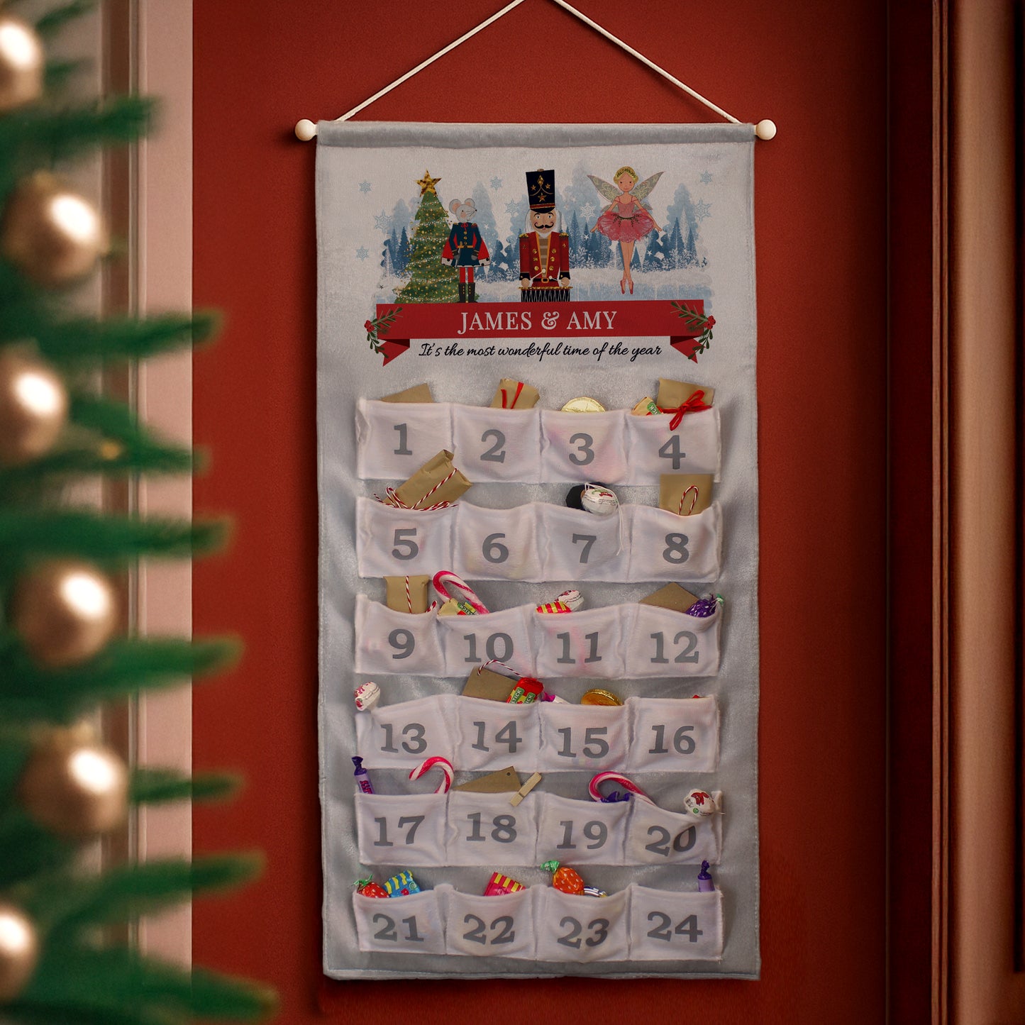 Personalised Christmas advent calendar with festive design on a red wall.