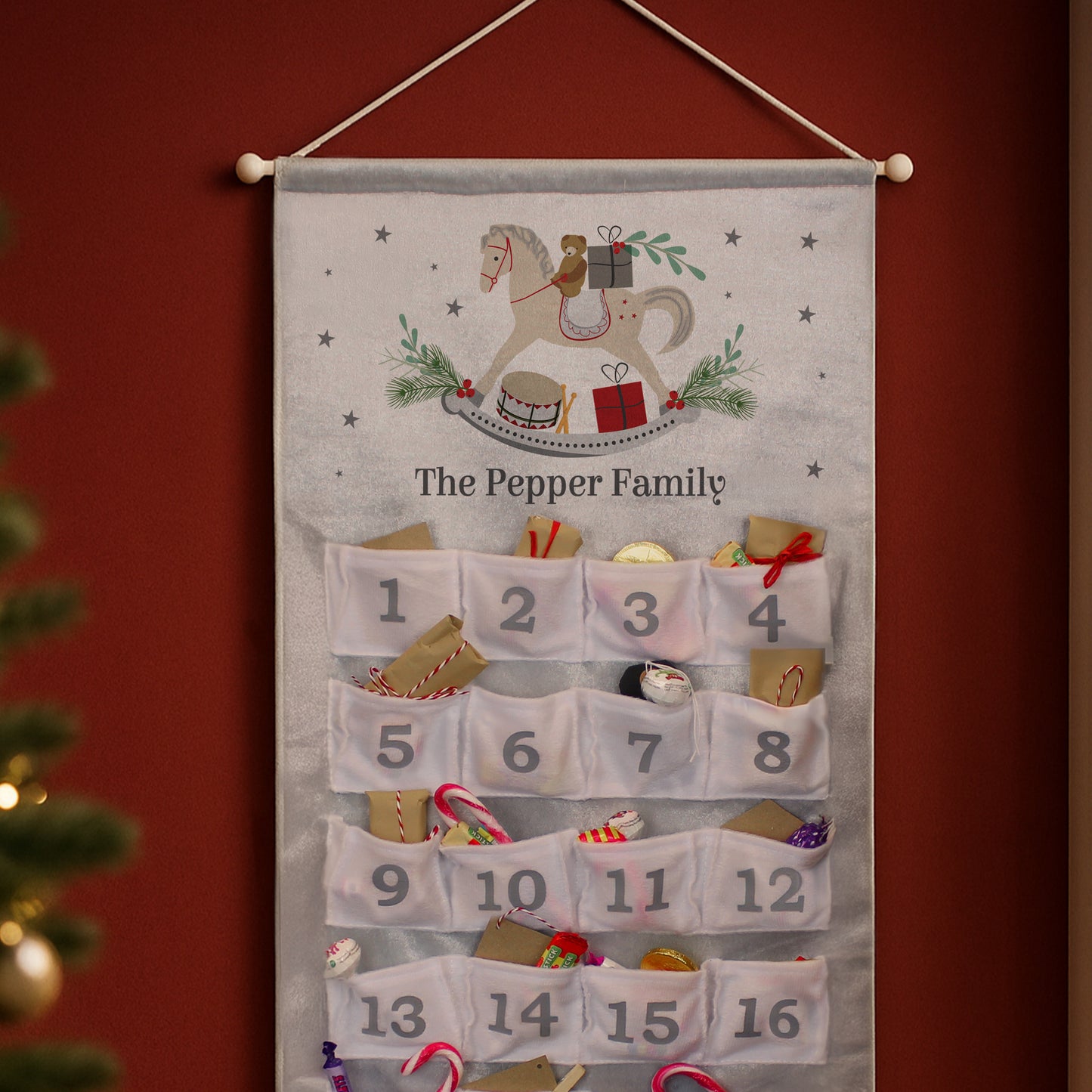 Advent calendar with embroidered design and numbered pockets against a red background