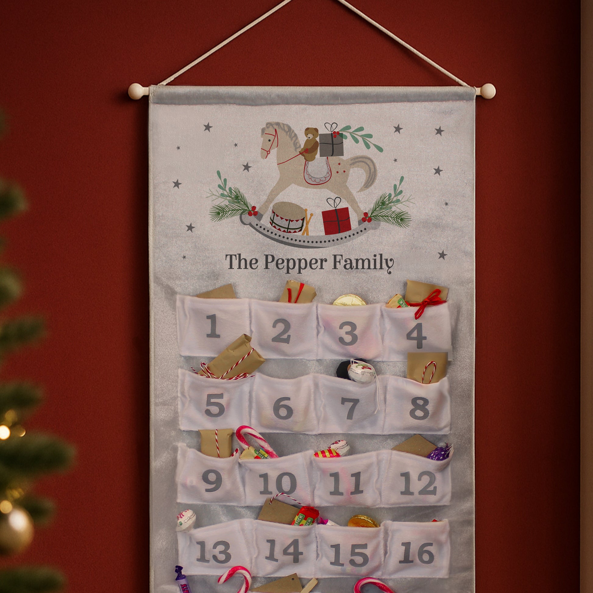 Advent calendar with embroidered design and numbered pockets against a red background