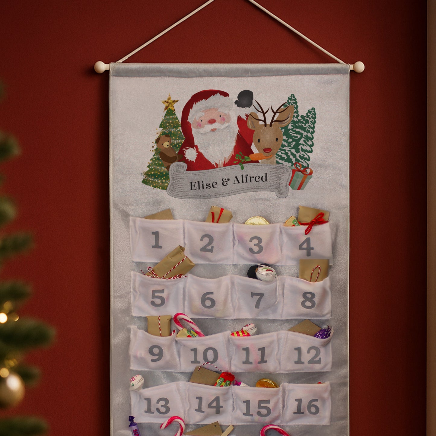 Personalised Advent calendar with Santa Claus and reindeer design on a red wall.