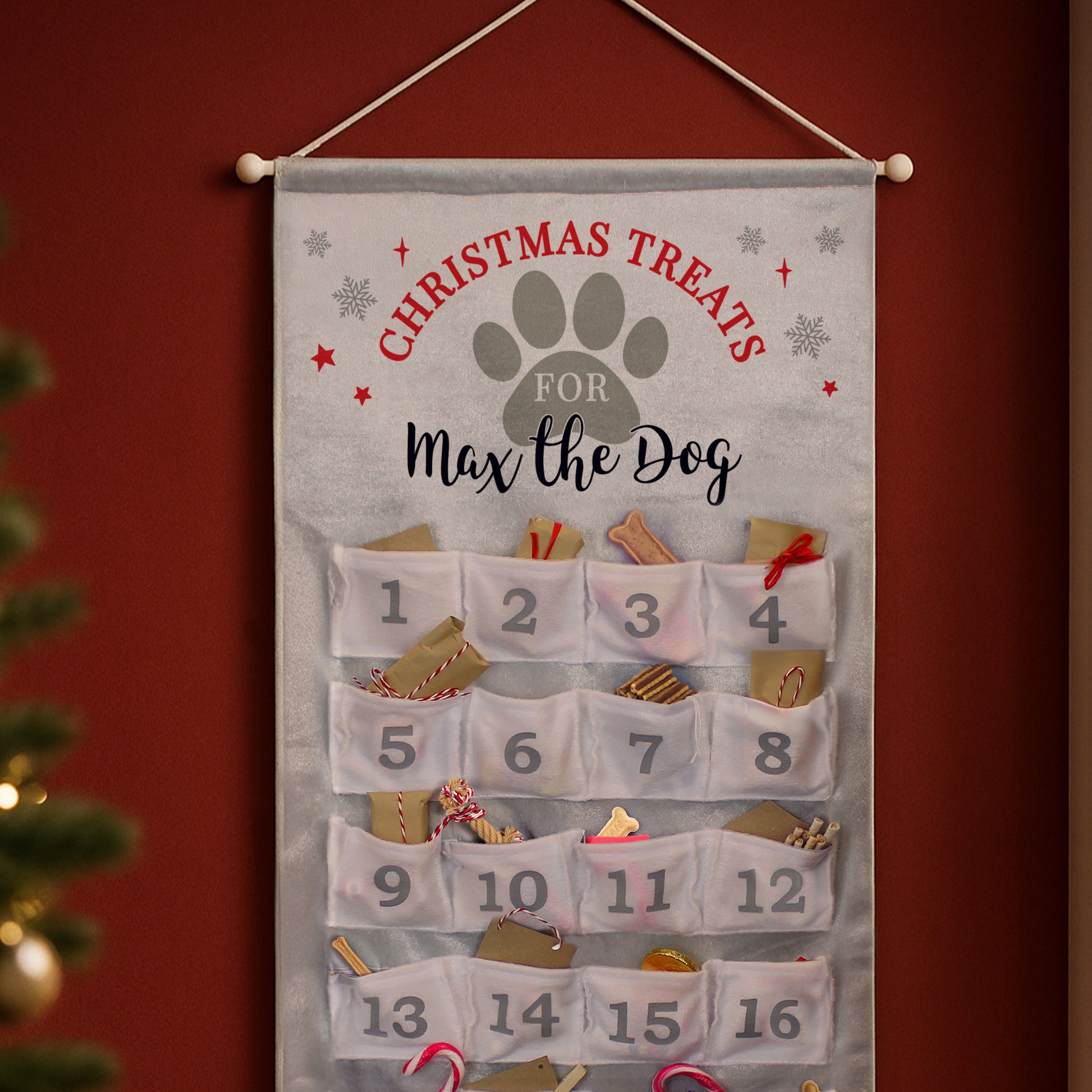 Dog-themed advent calendar with treats for a pet named Max, hanging against a red background.