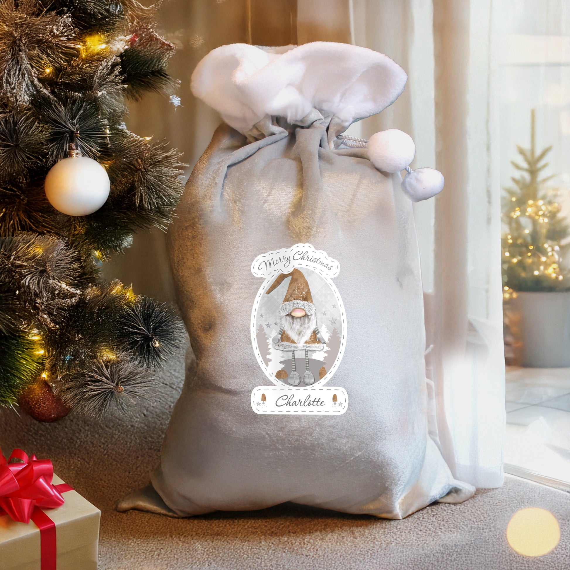 Personalised Decorative sack with a Christmas design next to a Christmas tree and presents.