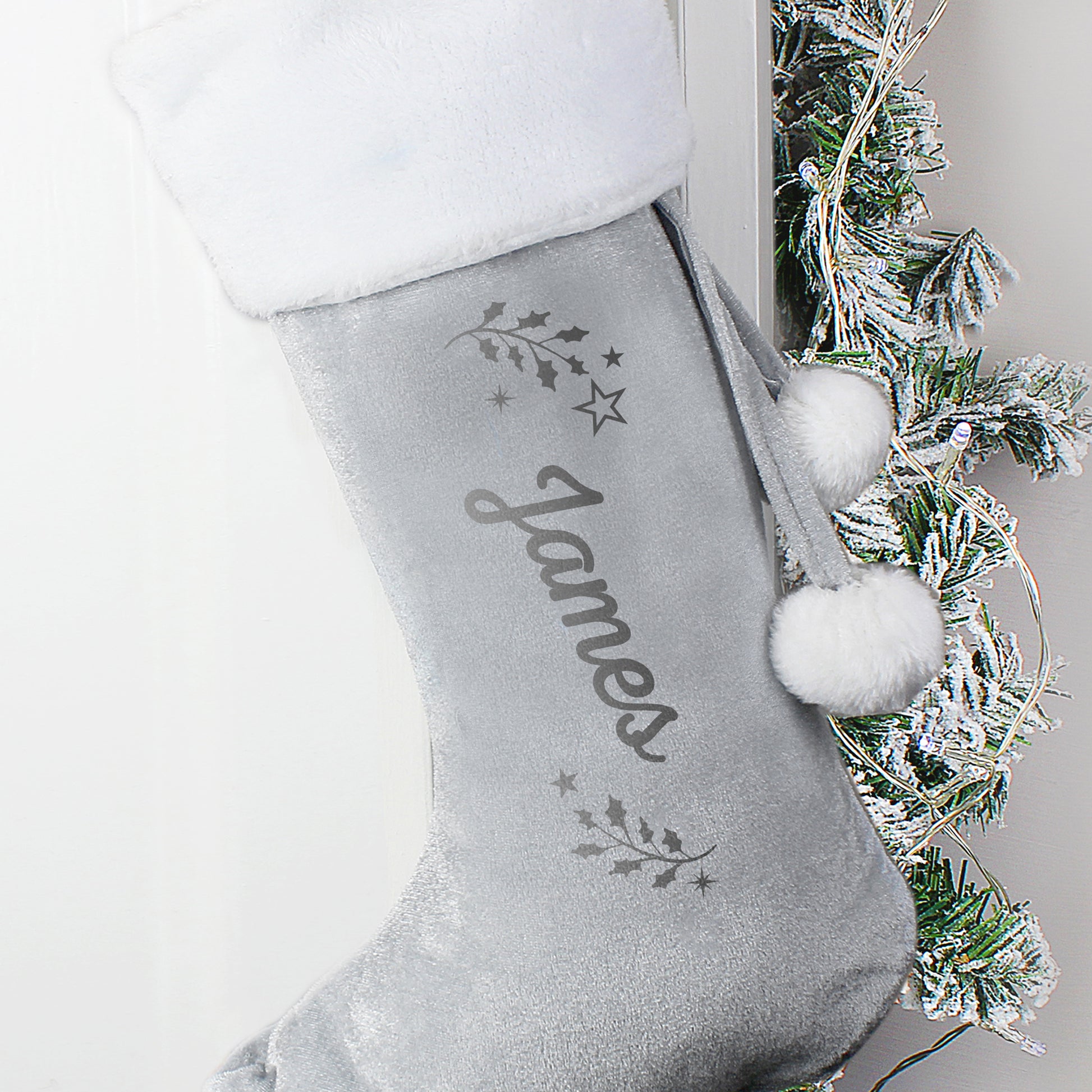 Grey Christmas stocking with 'James' embroidered on it, hanging against a neutral background.