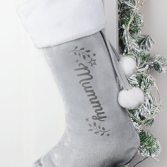 Personalised Grey Christmas stocking with 'mummy' and pom-poms, against a neutral background.