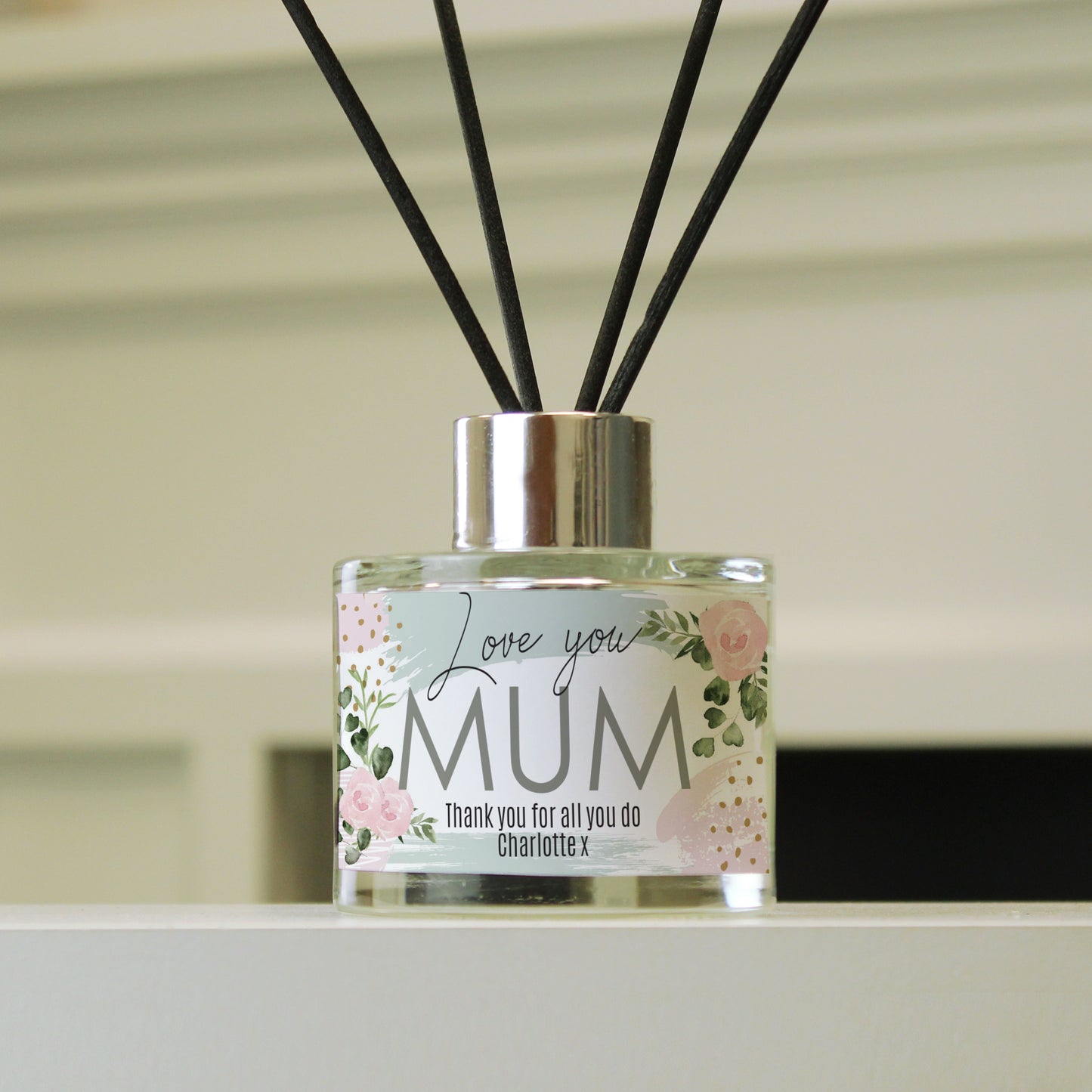 Diffuser with floral label saying 'Love you MUM' on a neutral background