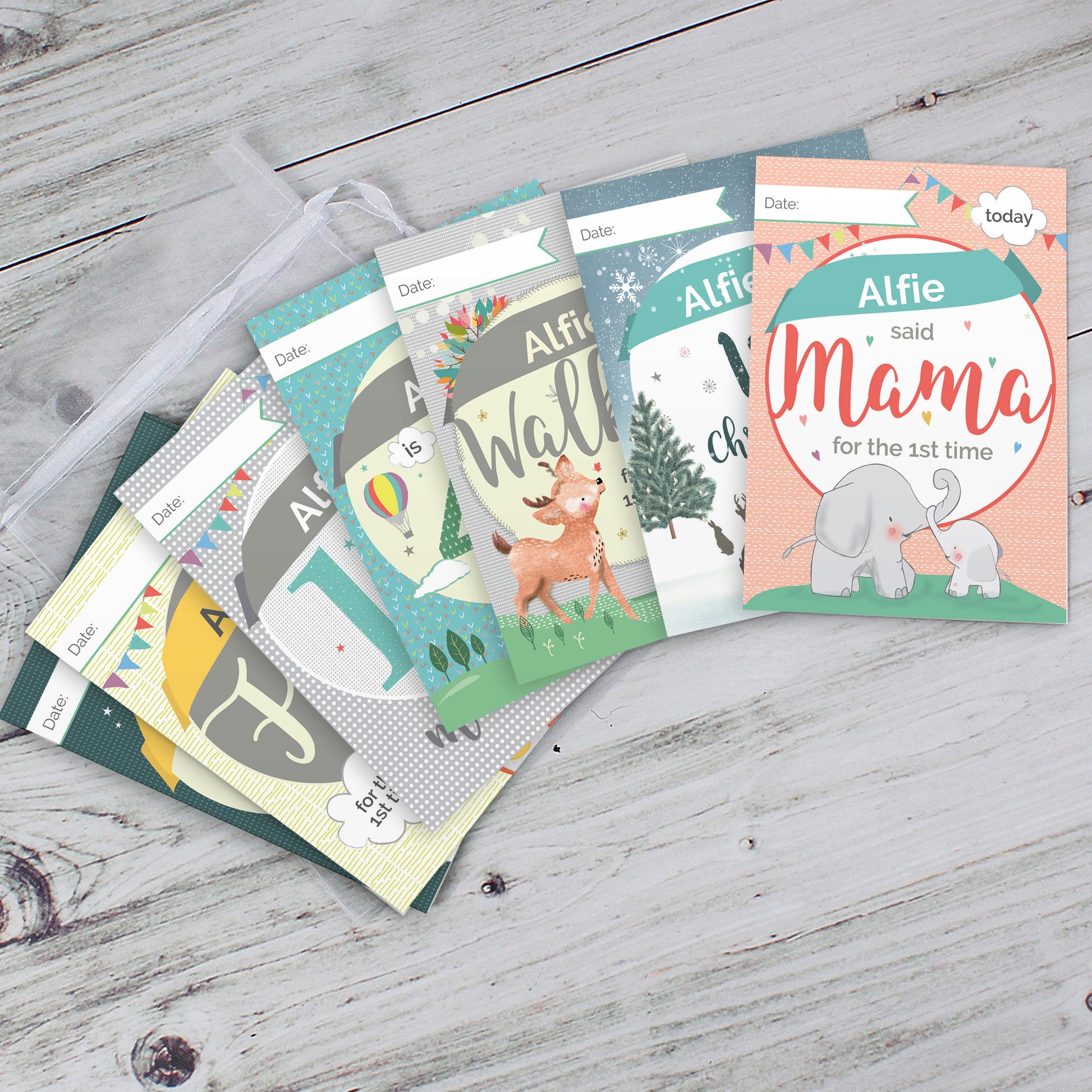 Collection of baby milestone cards on a wooden surface