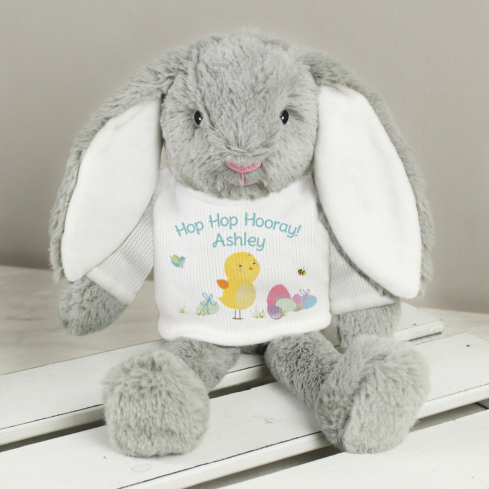 Personalised Grey plush bunny with a white shirt on a wooden surface