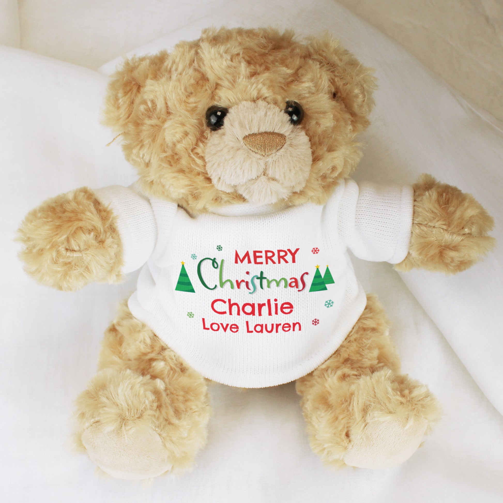 Teddy bear wearing a 'Merry Christmas Charlie Love Lauren' shirt on a white background