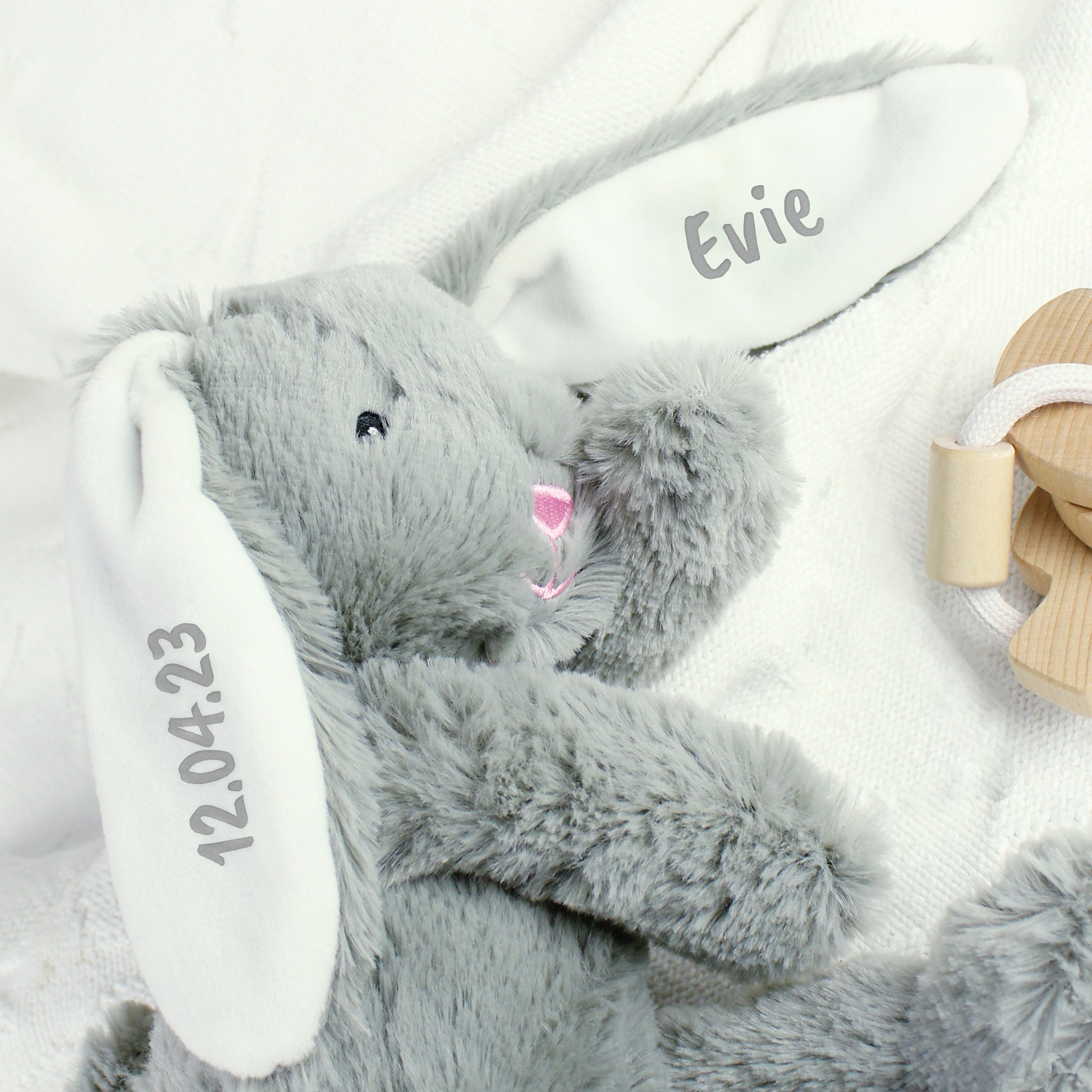 Grey bunny plush toy with personalised name and date on a white background