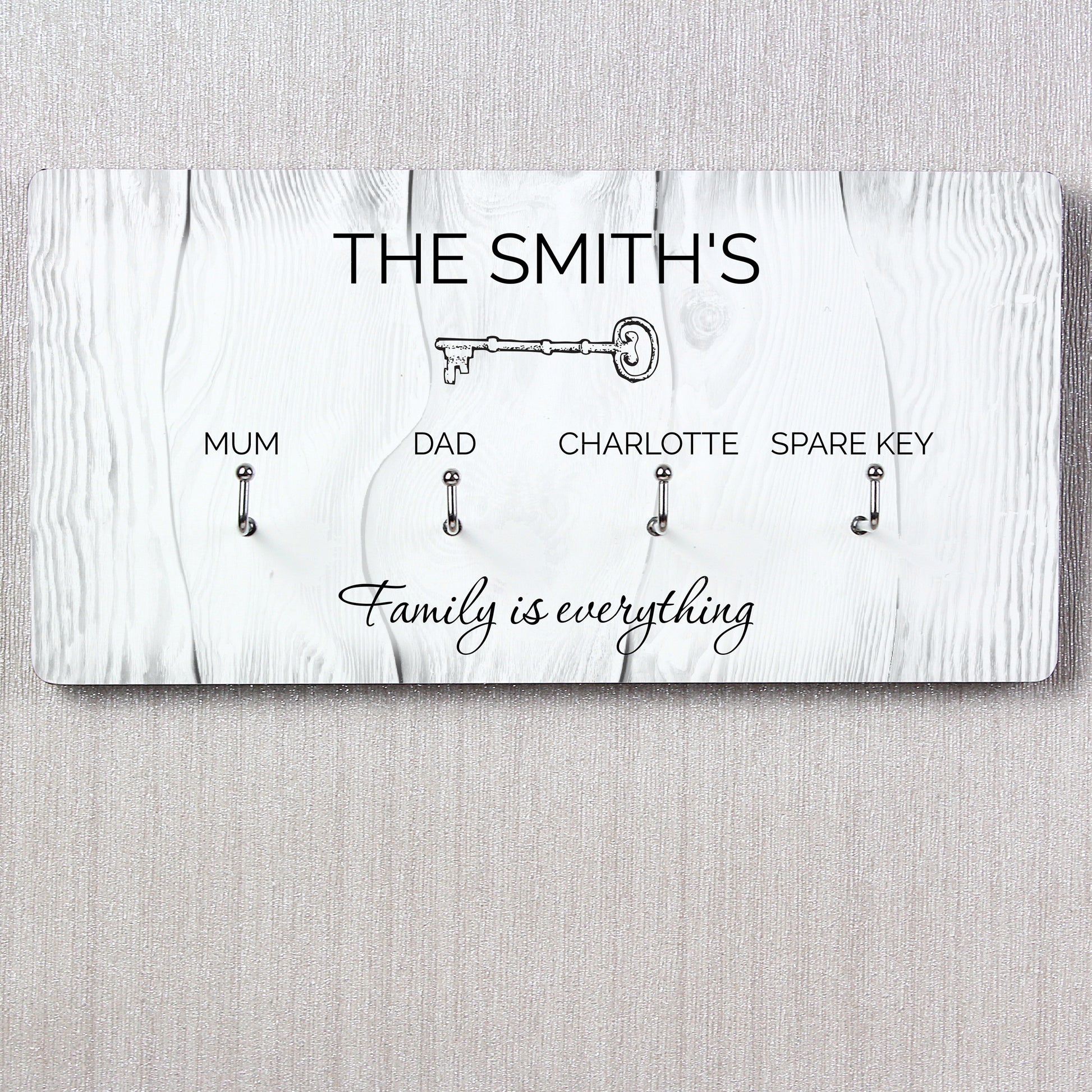 Personalised Key holder with keys for 'Mum', 'Dad', 'Charlotte', and 'Spare Key' on a white wooden background.