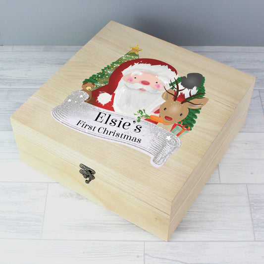 Wooden box with Santa Claus and reindeer design, labeled 'Elsie's First Christmas', on a light wooden surface.