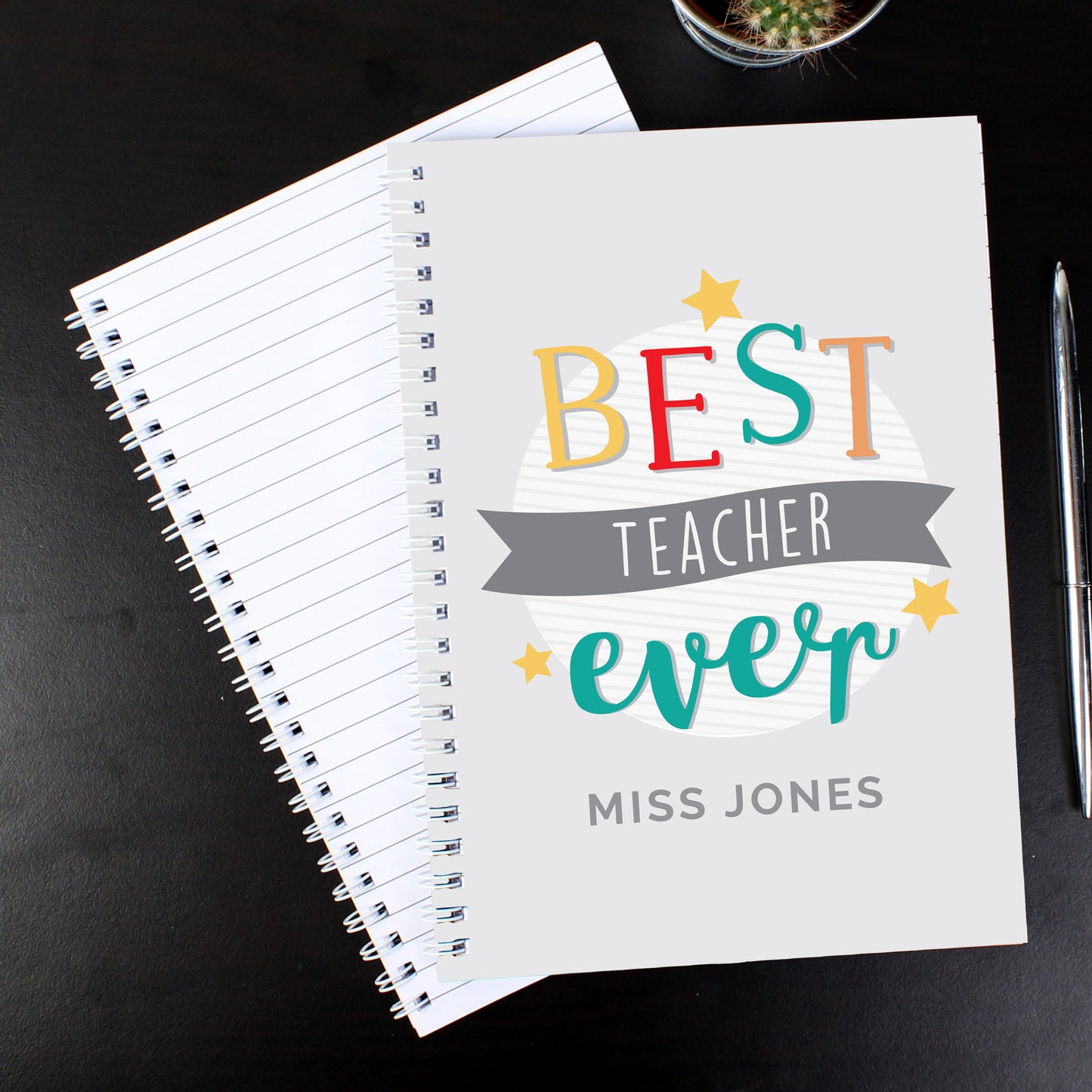 Notebook with 'Best Teacher Ever' design on a dark surface