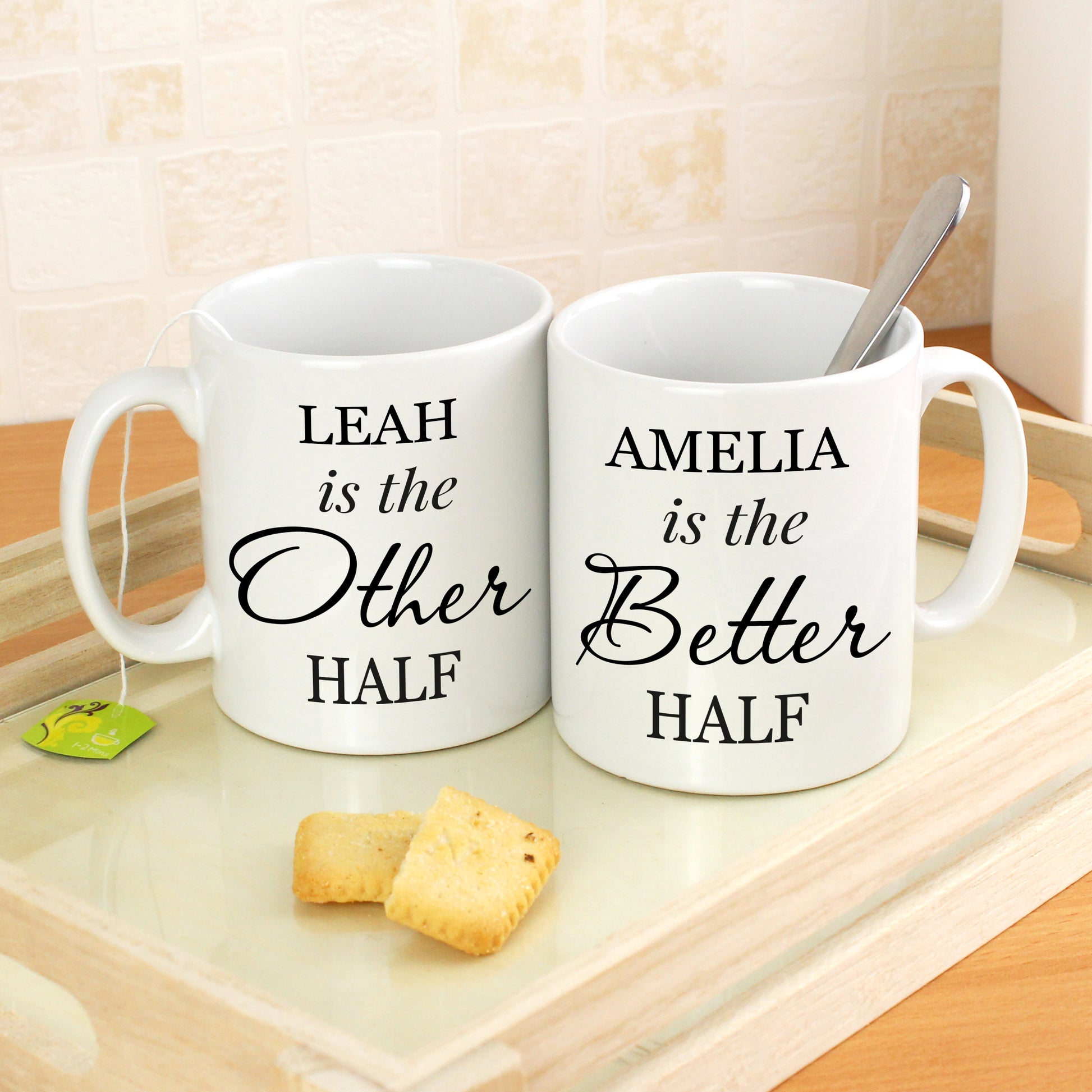 Two personalised white mugs with humorous text on a wooden surface.