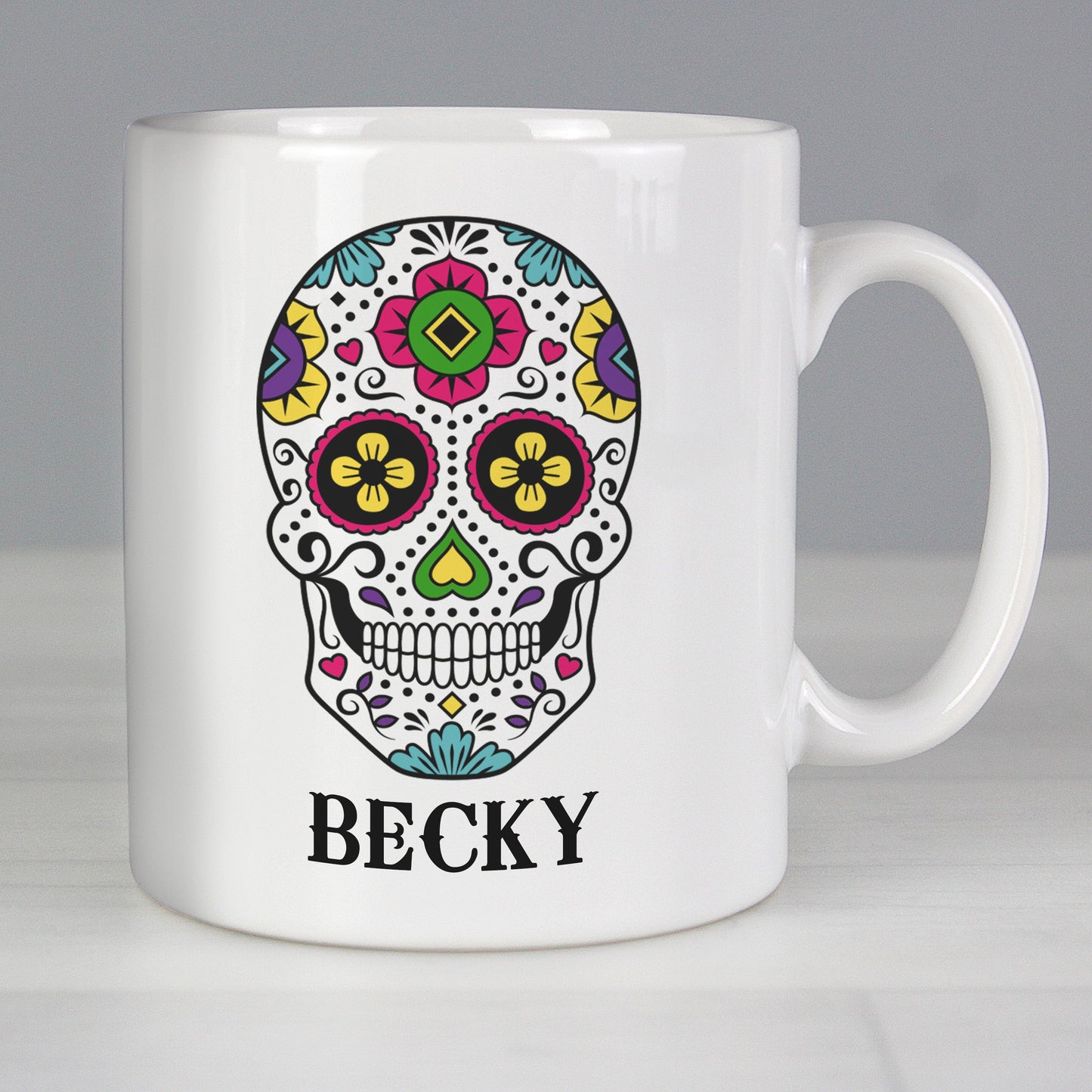 White mug with a colourful skull design and the name 'Becky' on a grey background
