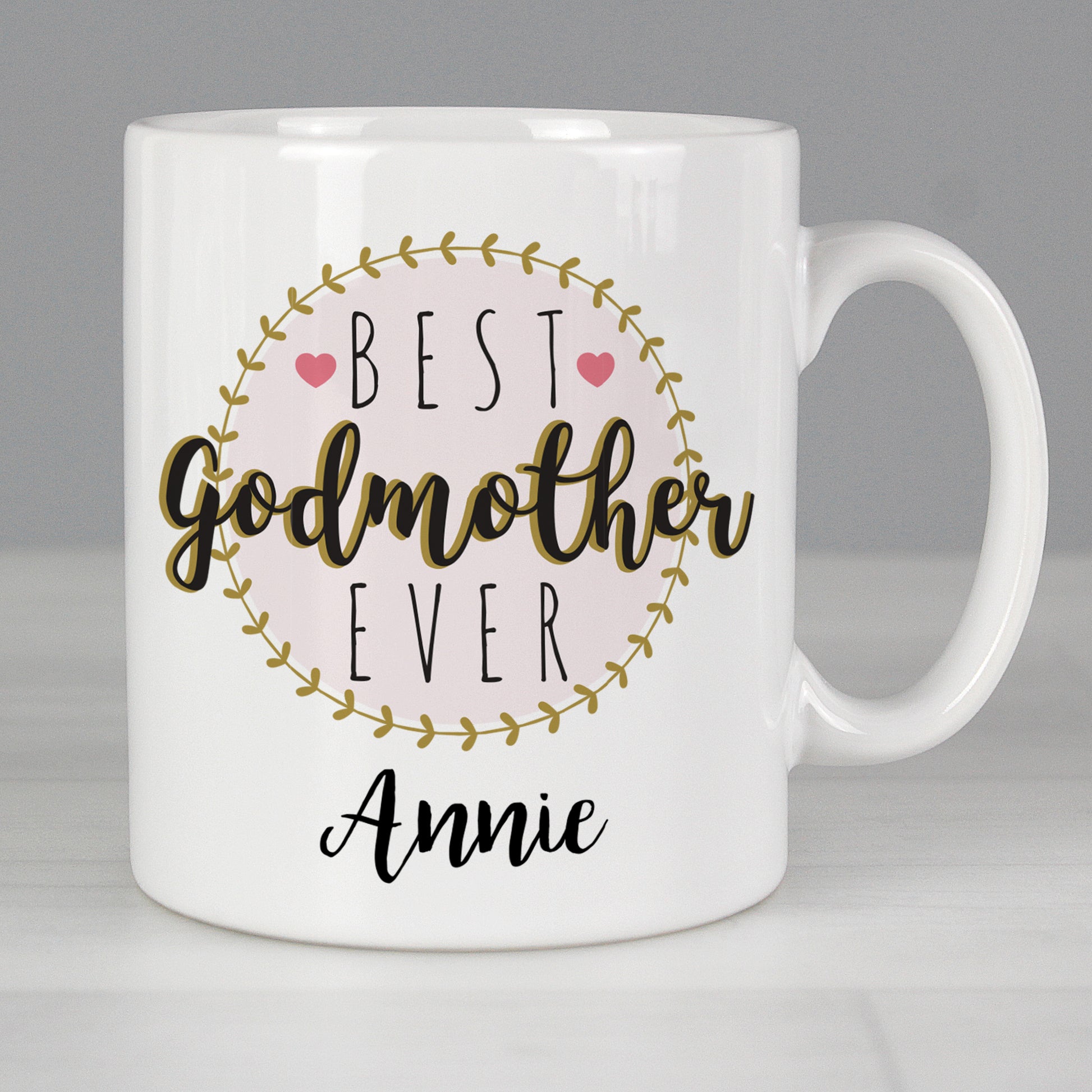 White mug with 'Best Godmother Ever Annie' text on a grey background