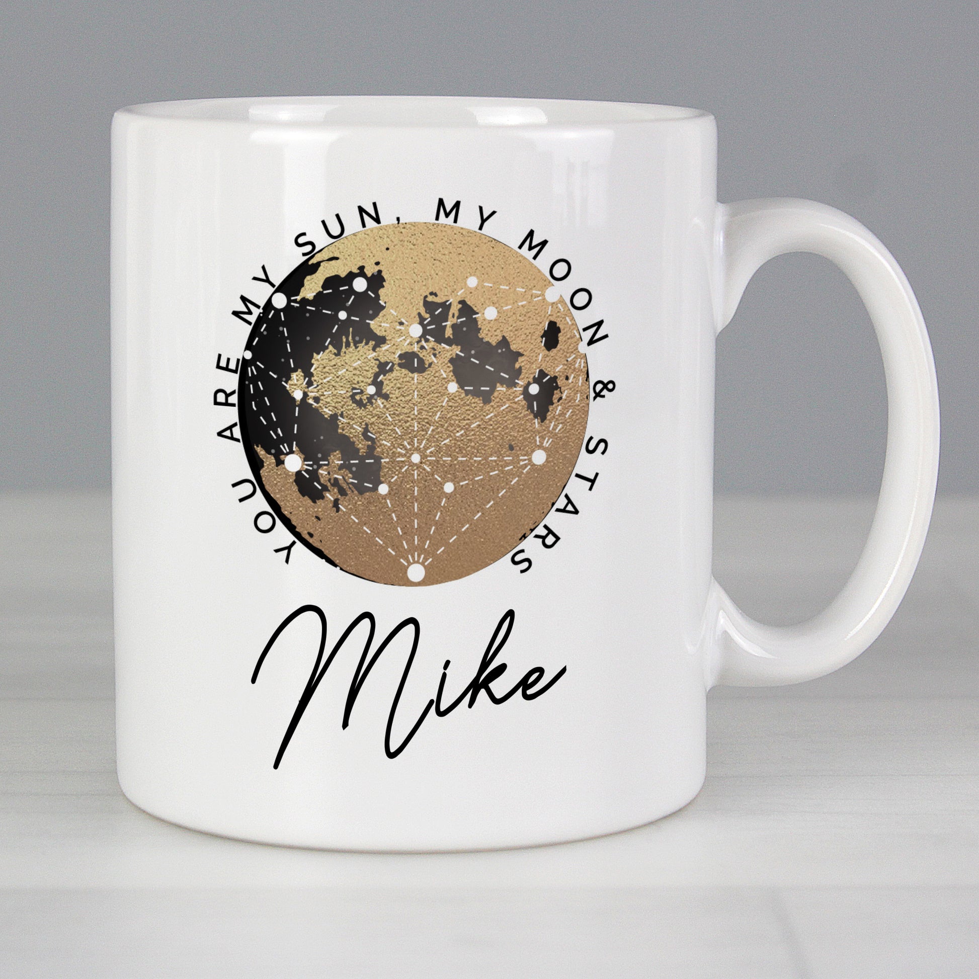 White mug with moon design and text on a grey background