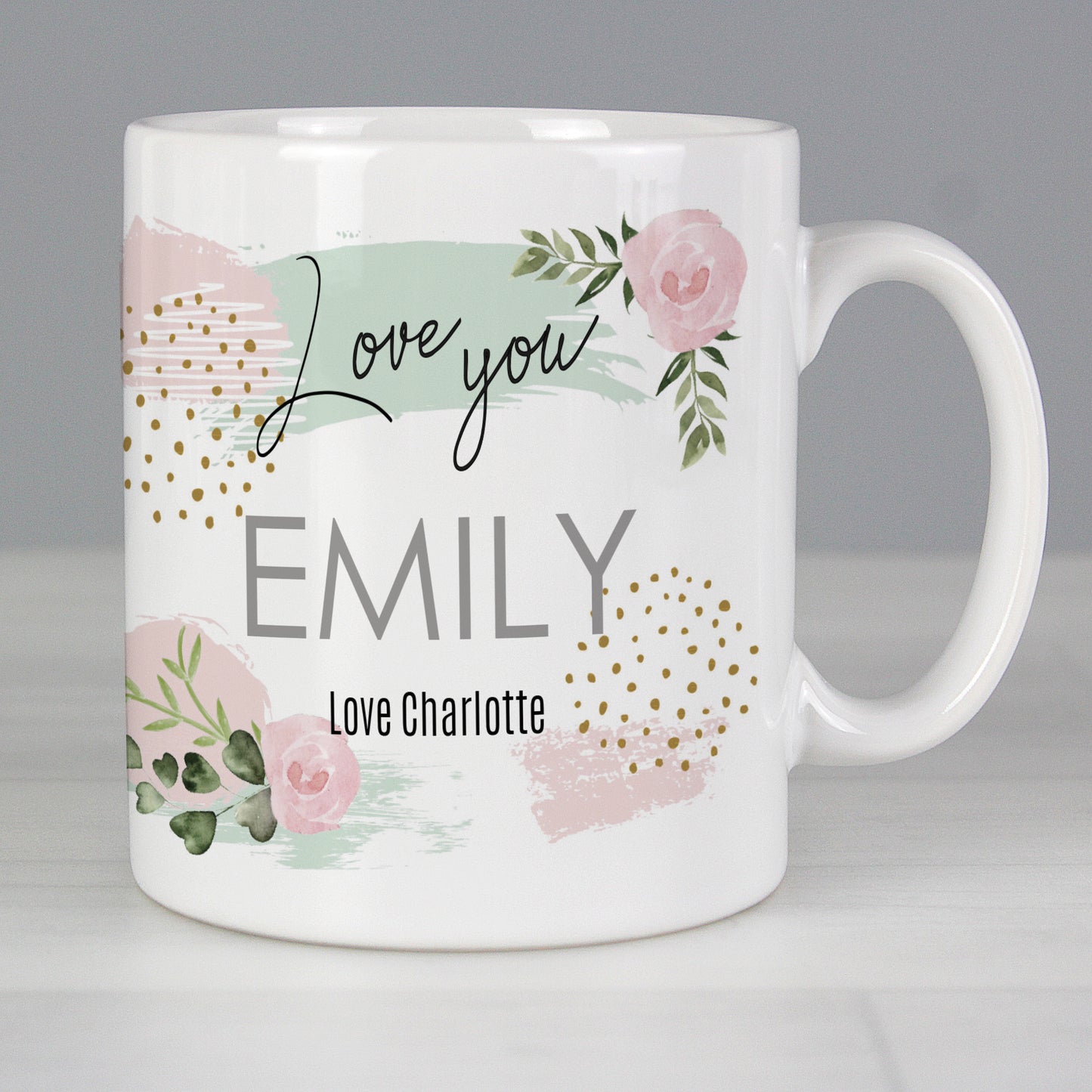 White mug with floral design and text on a grey background