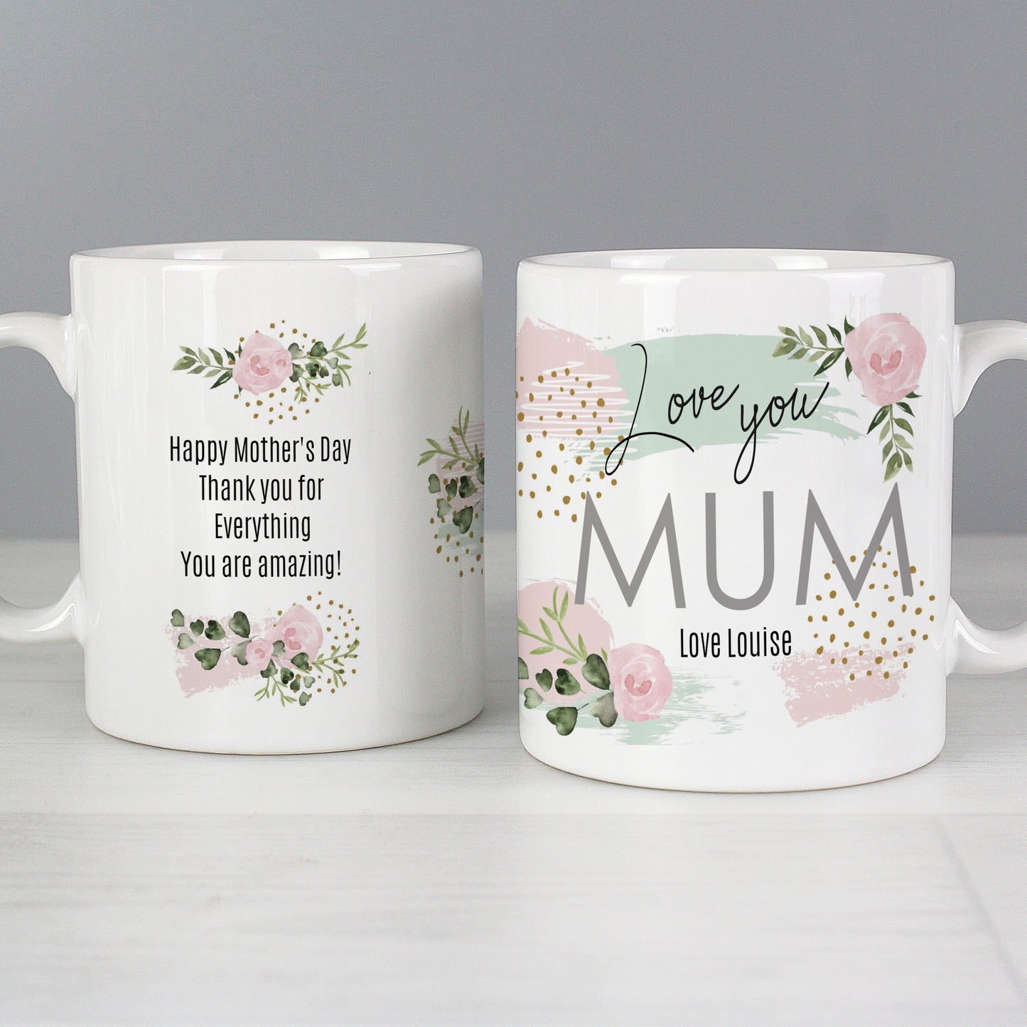 Two personalised white mugs with floral designs and Mother's Day messages on a grey background