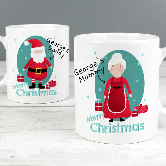 Two Christmas-themed mugs with illustrations of Santa Claus and a woman, labeled 'George's Daddy' and 'George's Mummy', on a white surface.