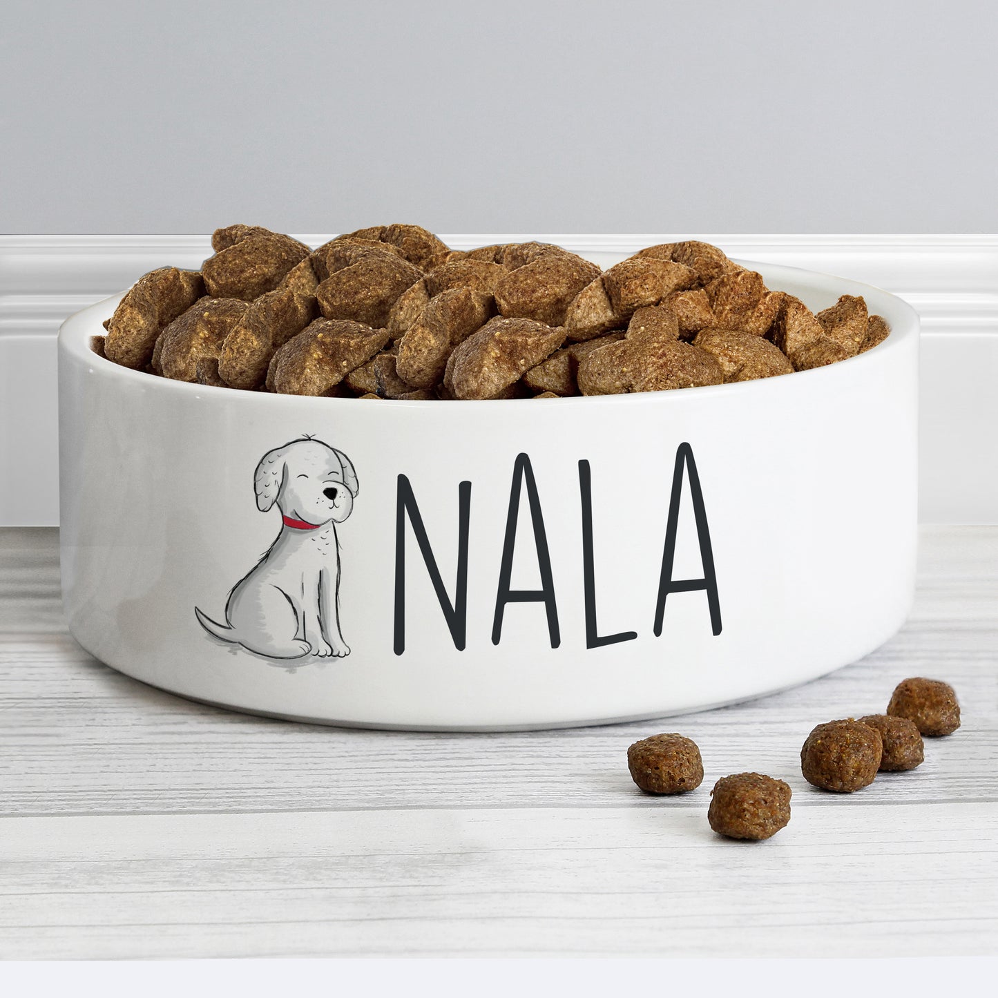 Dog food bowl with 'Nala' and a dog illustration on a white surface