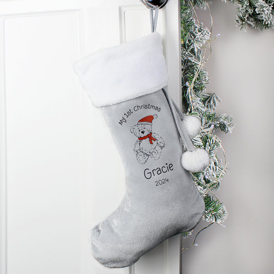 Personalised Christmas stocking with a teddy bear design and text, hanging on a white door with festive decorations.