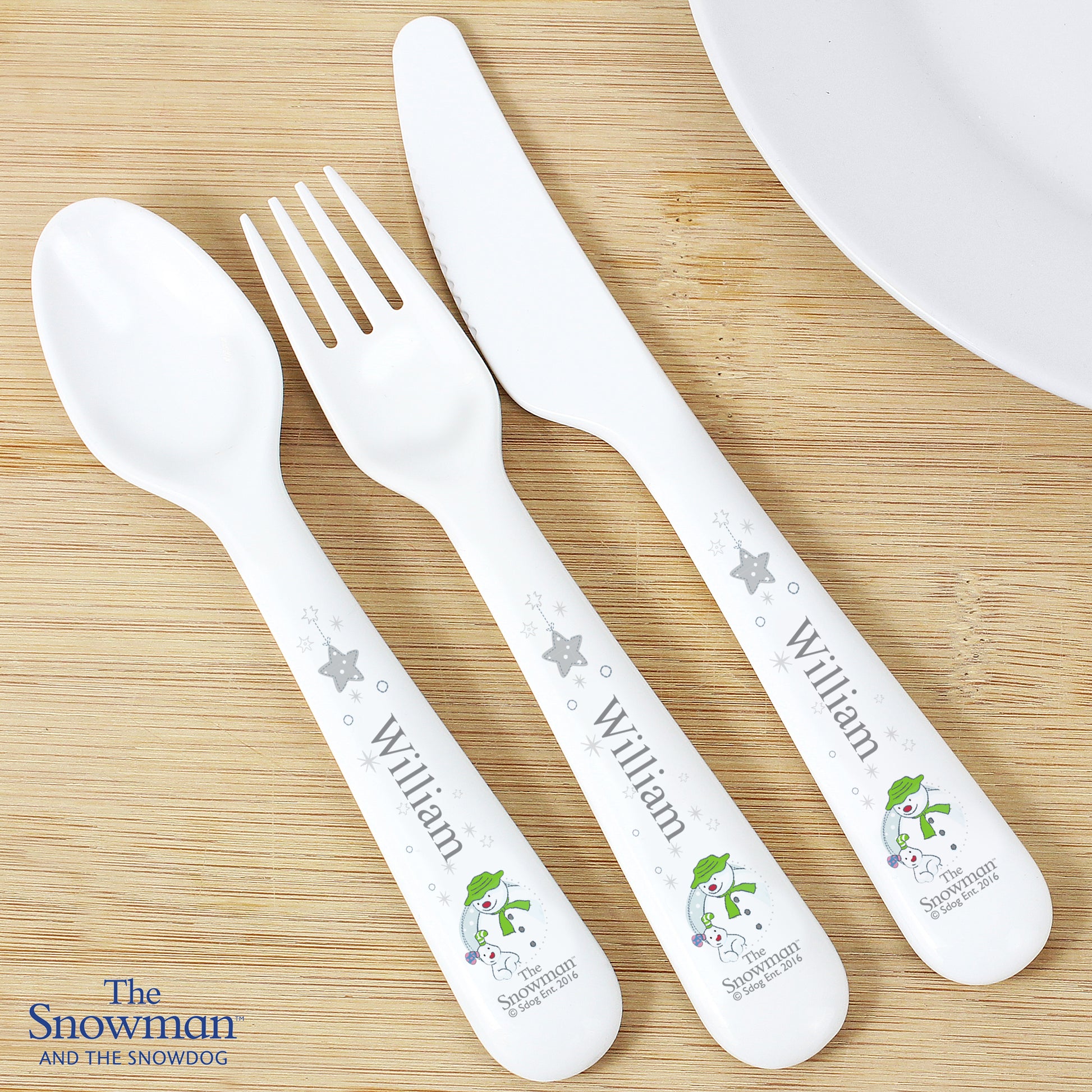 Personalised 'The Snowman and the Snowdog' cutlery set on a wooden surface