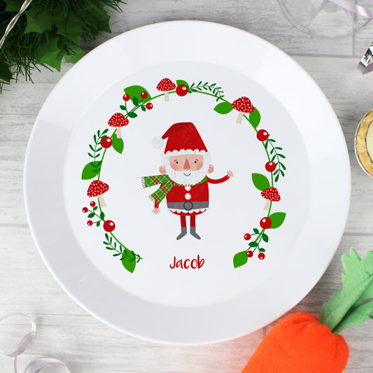White plate with a cartoon Santa Claus design and the name 'Jacob' on a wooden surface.