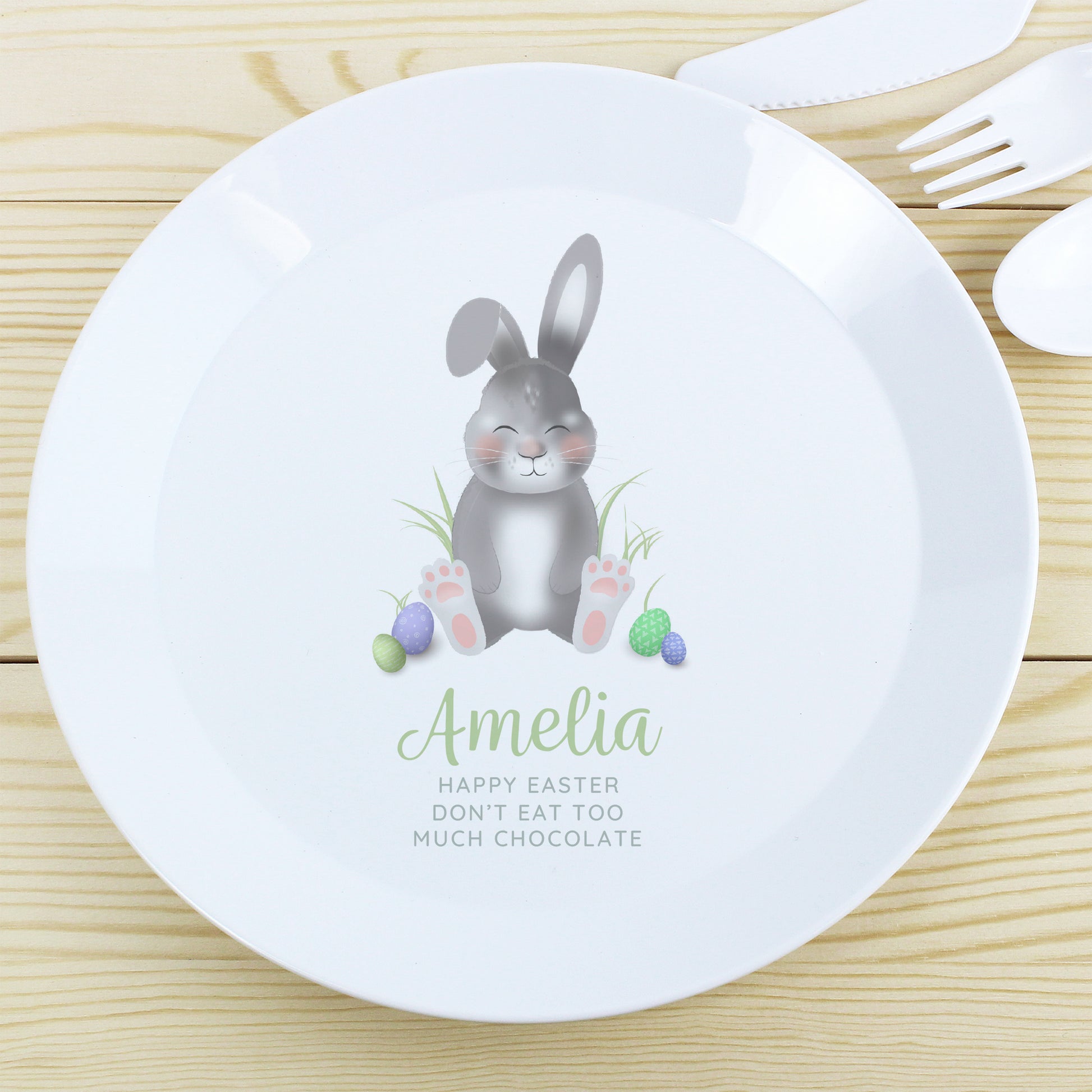 Children's plate with a bunny design and personalised text on a wooden surface